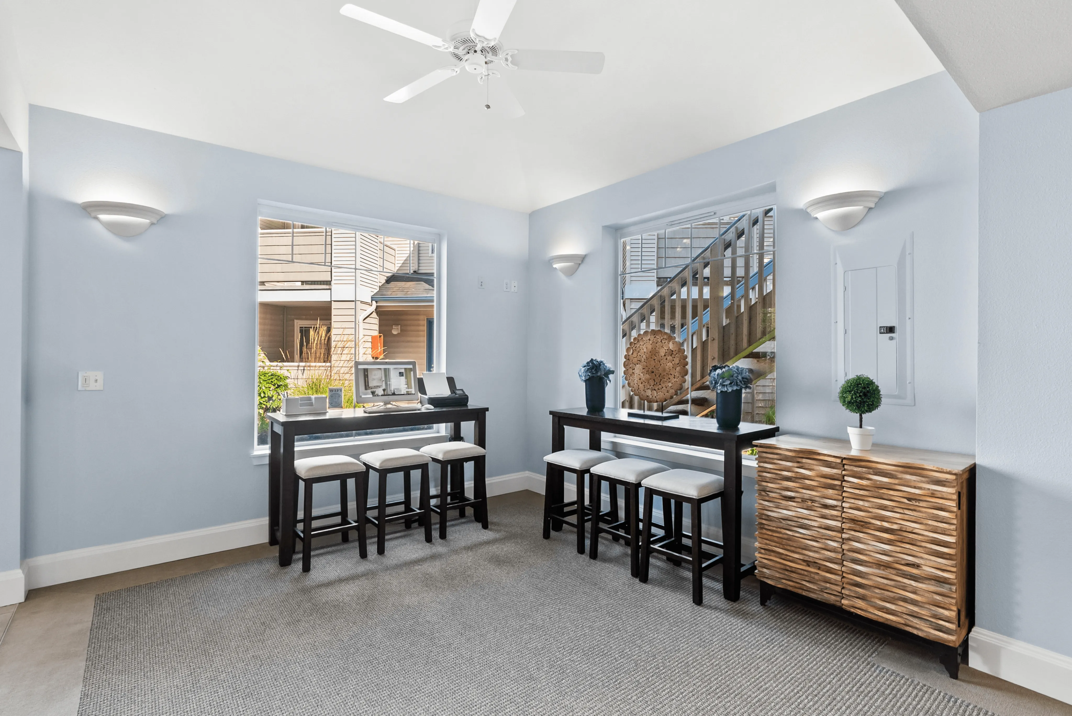 Charming apartment interior showcasing cozy dining area with contemporary furniture, elegant decor, and abundant natural light from large windows.