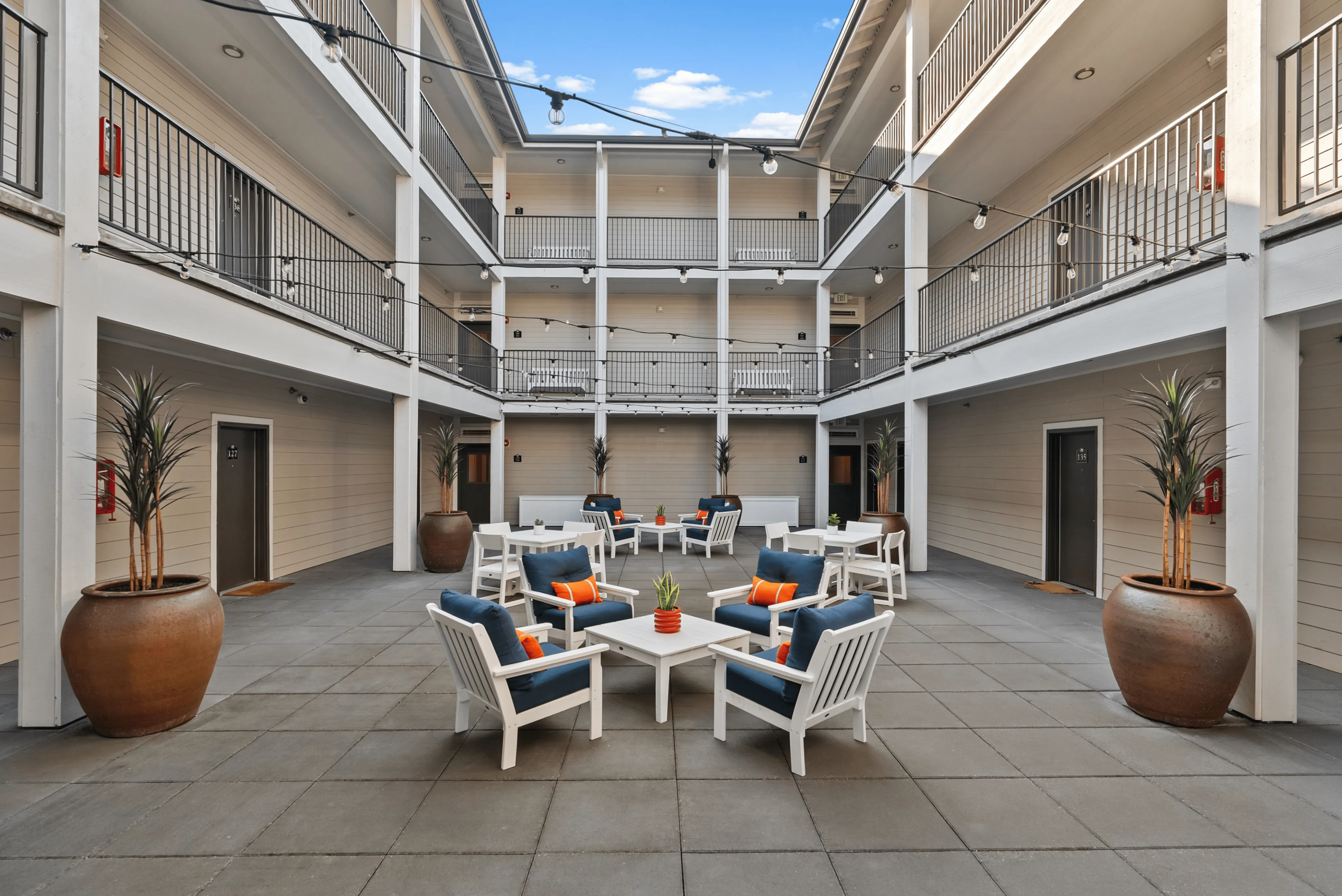 Inviting outdoor courtyard with chic seating, vibrant cushions, and stylish lighting, perfect for relaxation and socializing.