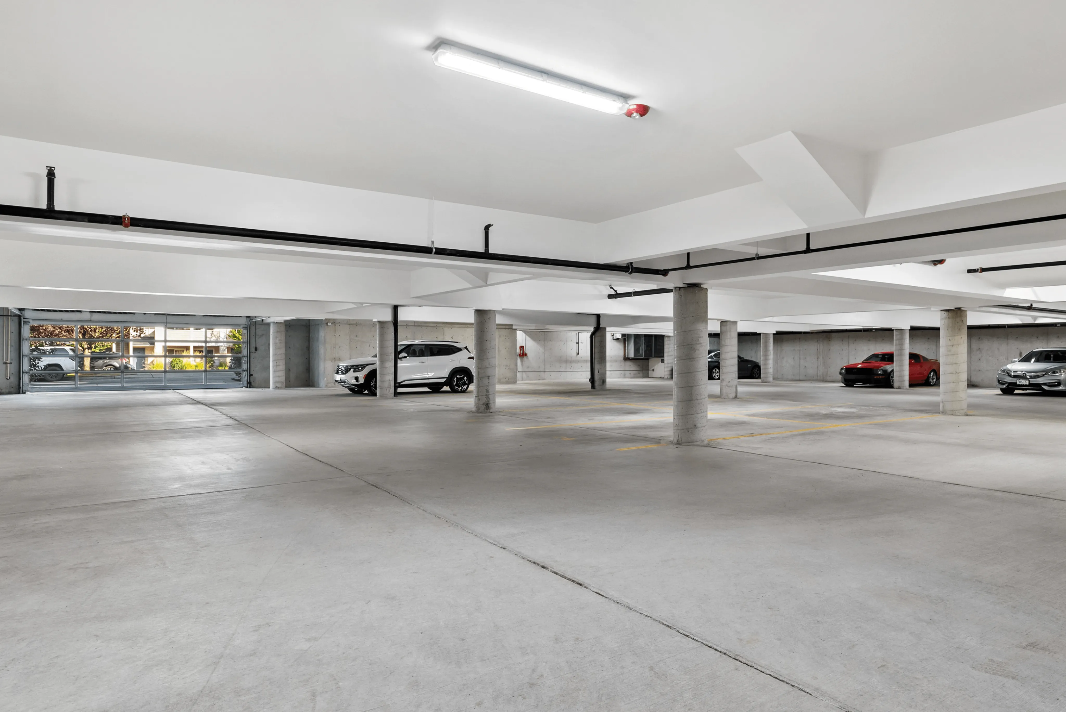 Spacious underground parking garage with ample lighting and multiple parking spaces, offering convenience and security.