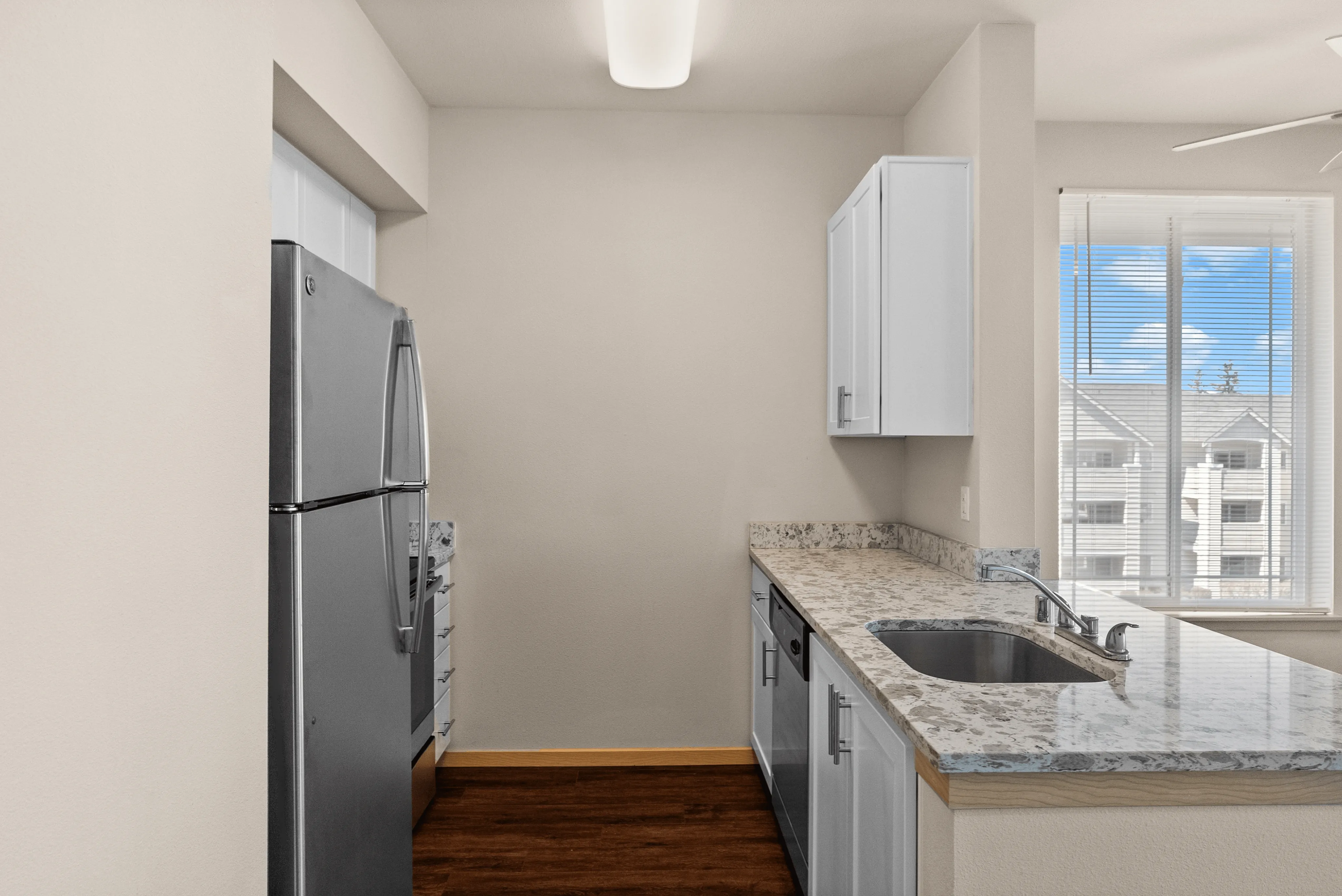 Modern kitchen with sleek stainless steel appliances, elegant granite countertops, and ample natural light from large windows.