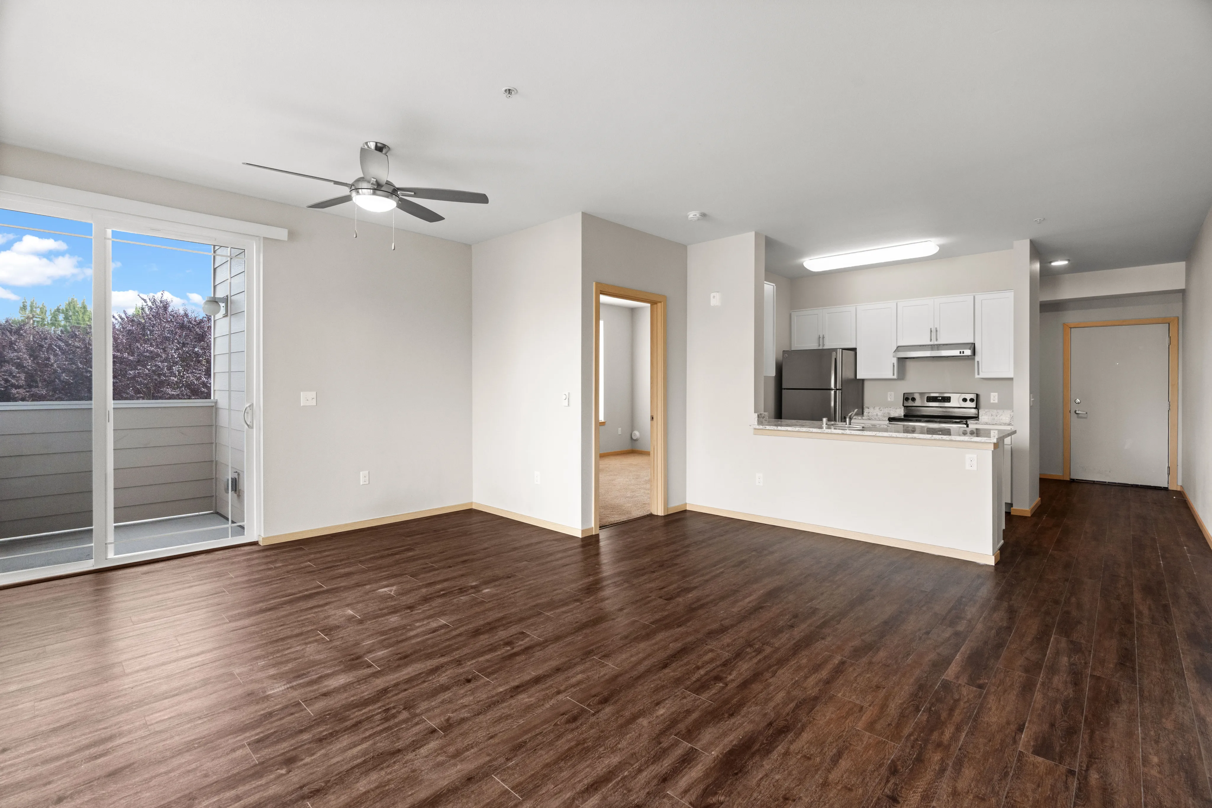 Bright and airy open-concept apartment with sleek hardwood floors, modern kitchen, and a private balcony with scenic views.
