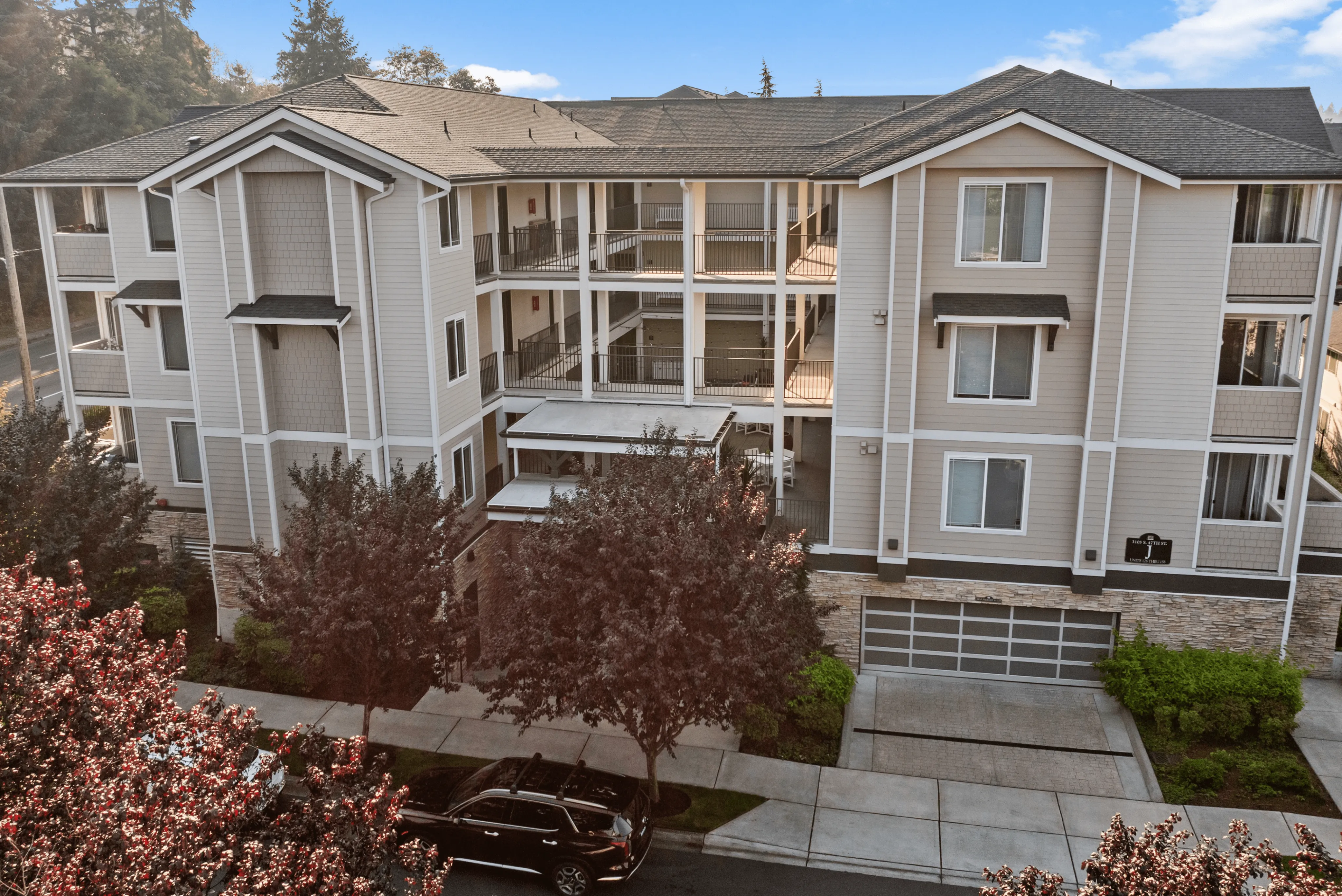 Charming four-story apartment building with modern design, surrounded by lush greenery and a serene atmosphere.