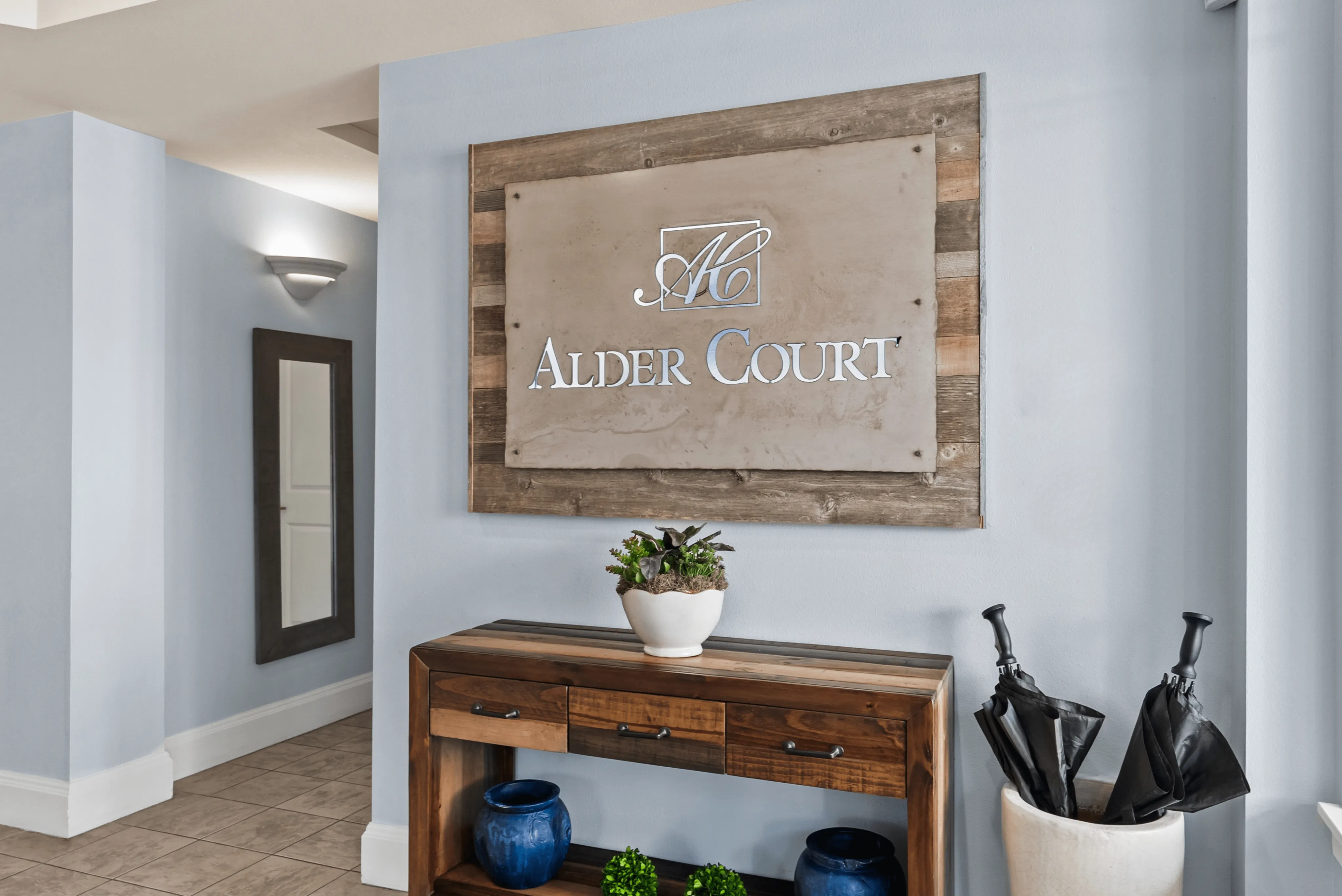 Elegant entryway of Alder Court featuring a chic wooden console table with modern decor, creating a warm welcome.