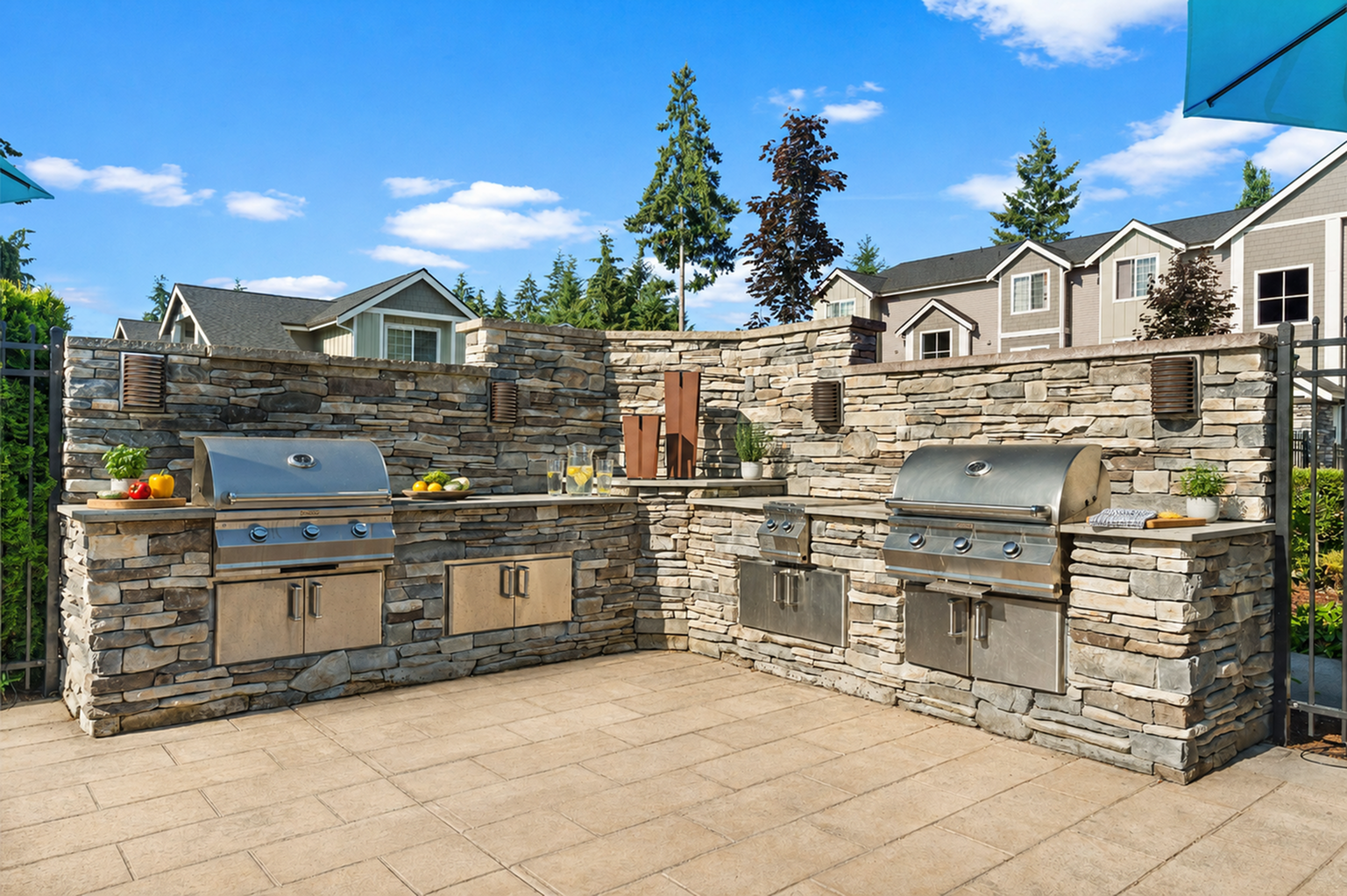 Luxurious outdoor kitchen with stone BBQ grills, surrounded by scenic views and blue skies, perfect for entertaining.