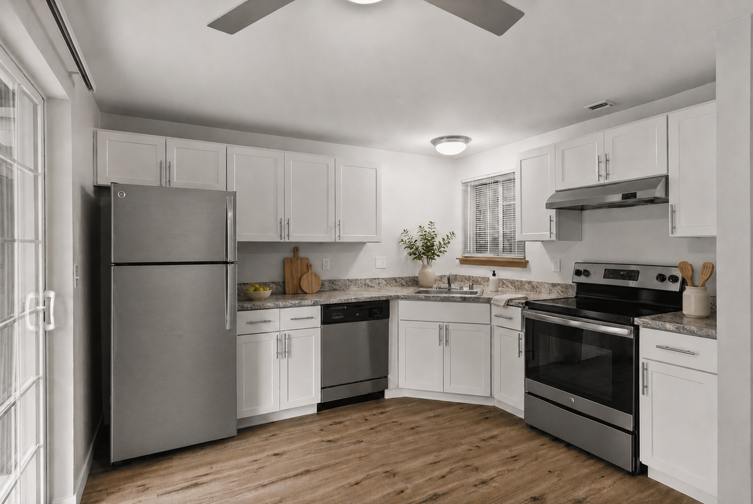Modern kitchen design with sleek stainless steel appliances, elegant white cabinetry, and warm wooden flooring creating an inviting culinary space.