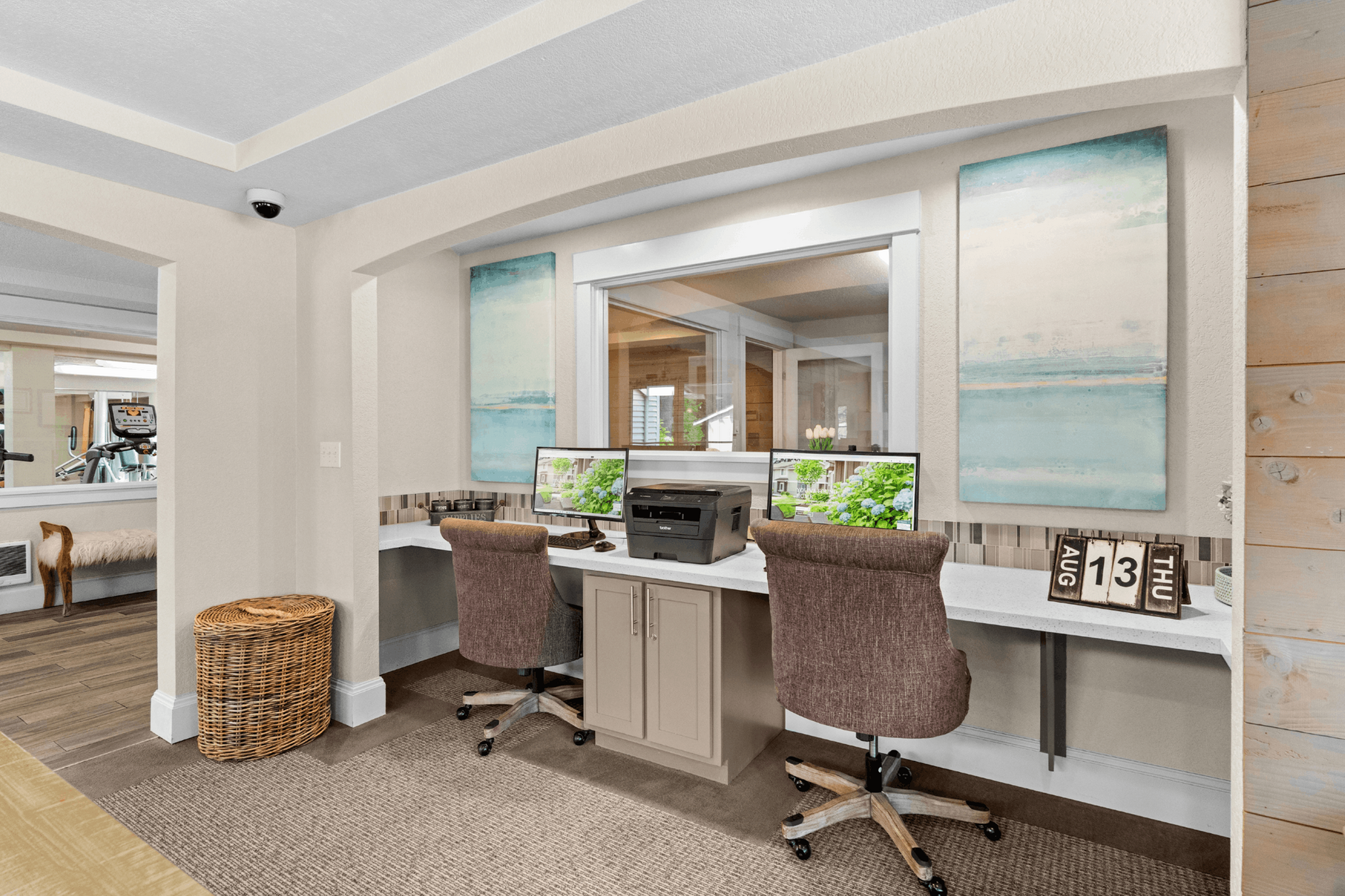 Bright and inviting home office space featuring dual monitors, elegant decor, and comfortable seating, perfect for productive workdays.