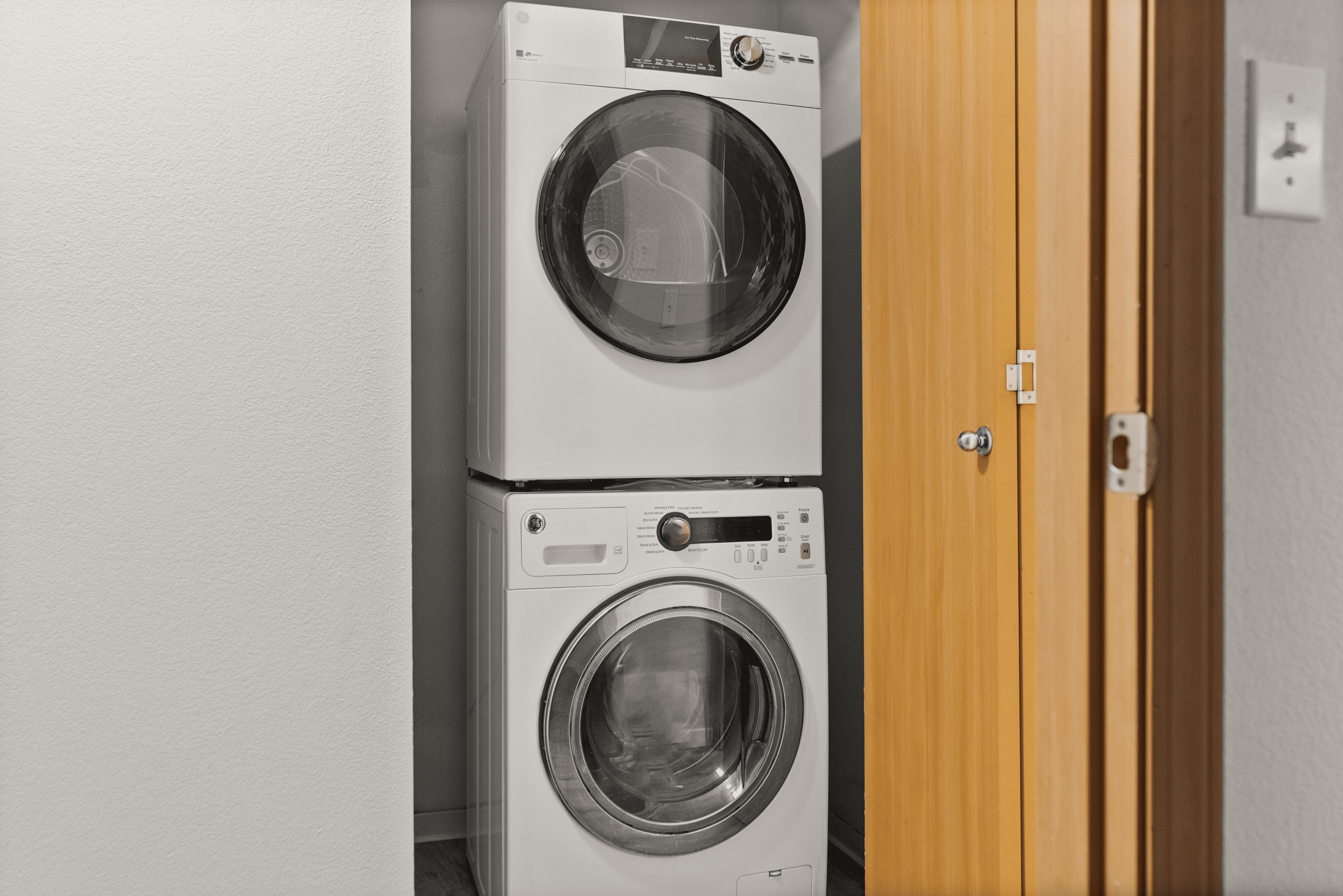 Sleek and modern stacked washer and dryer in a compact laundry nook, showcasing efficient space-saving design.