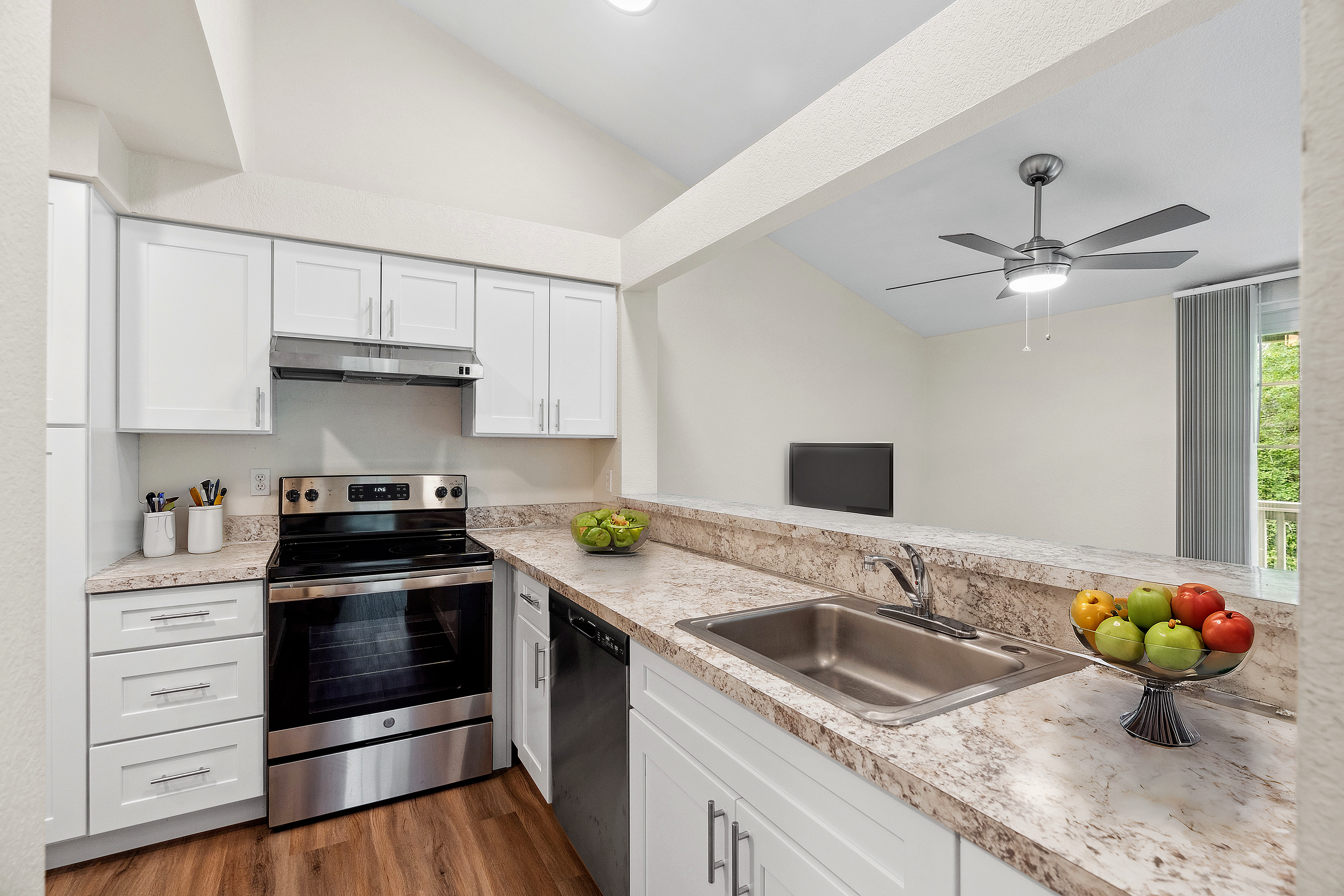 Bright modern kitchen with white cabinetry, stainless steel appliances, and marble countertops.