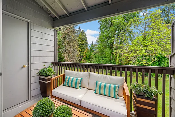 Charming balcony with cozy seating and lush green views, perfect for relaxation.
