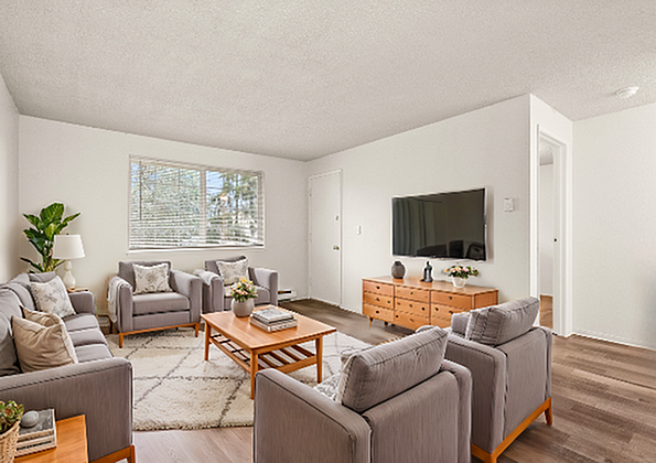Bright and inviting living room with modern furniture and a large flat-screen TV.