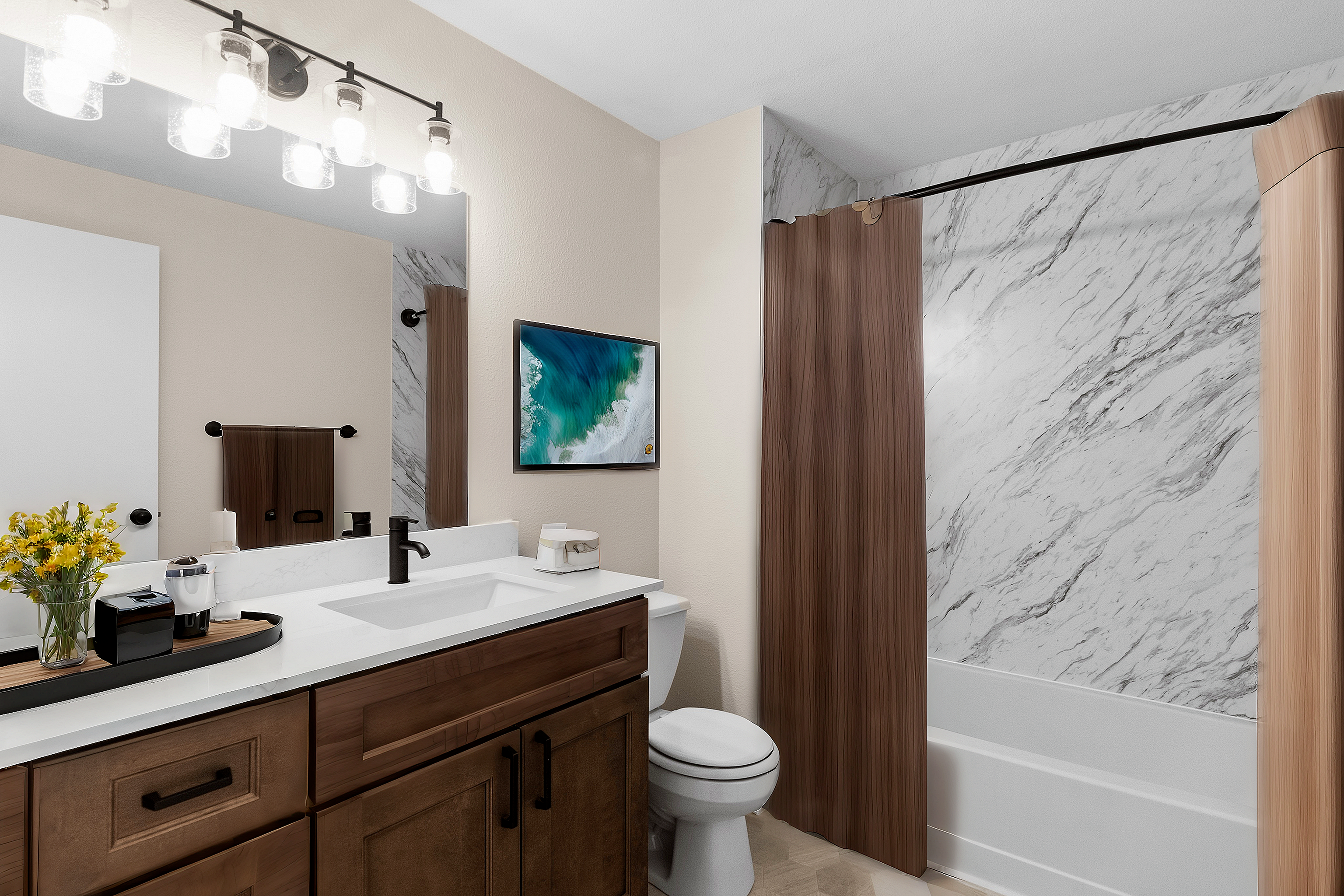 A modern bathroom with marble tiles, wooden cabinetry, and a large mirror illuminated by stylish lighting fixtures.