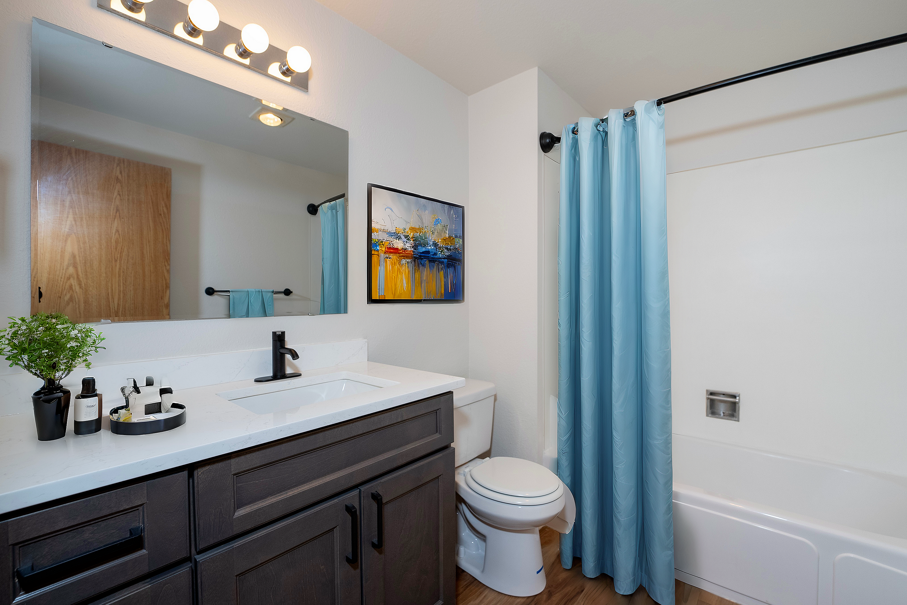 Modern bathroom featuring a sleek vanity, stylish mirror, and vibrant blue curtain.
