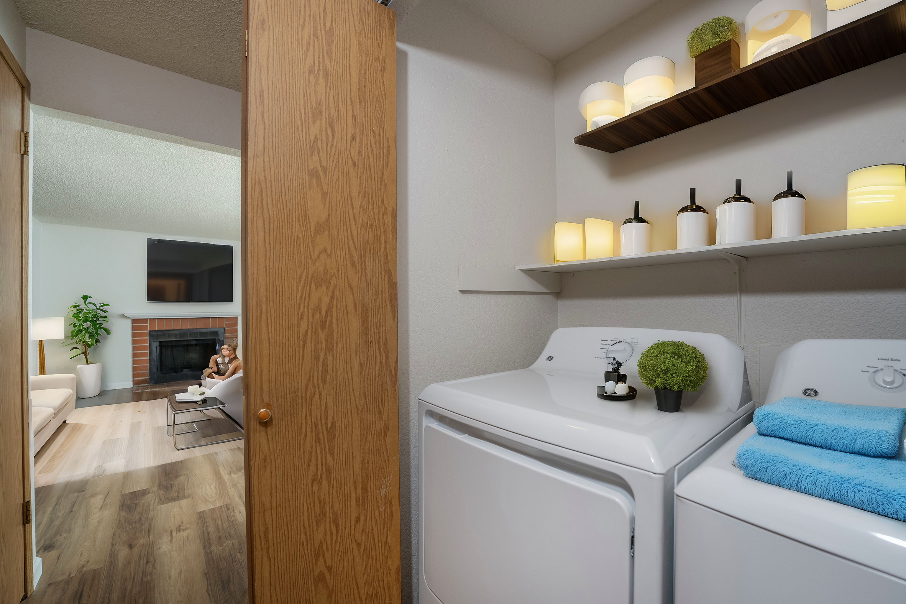 Bright and cozy room featuring a modern laundry area with washing machines and a living room with a fireplace.