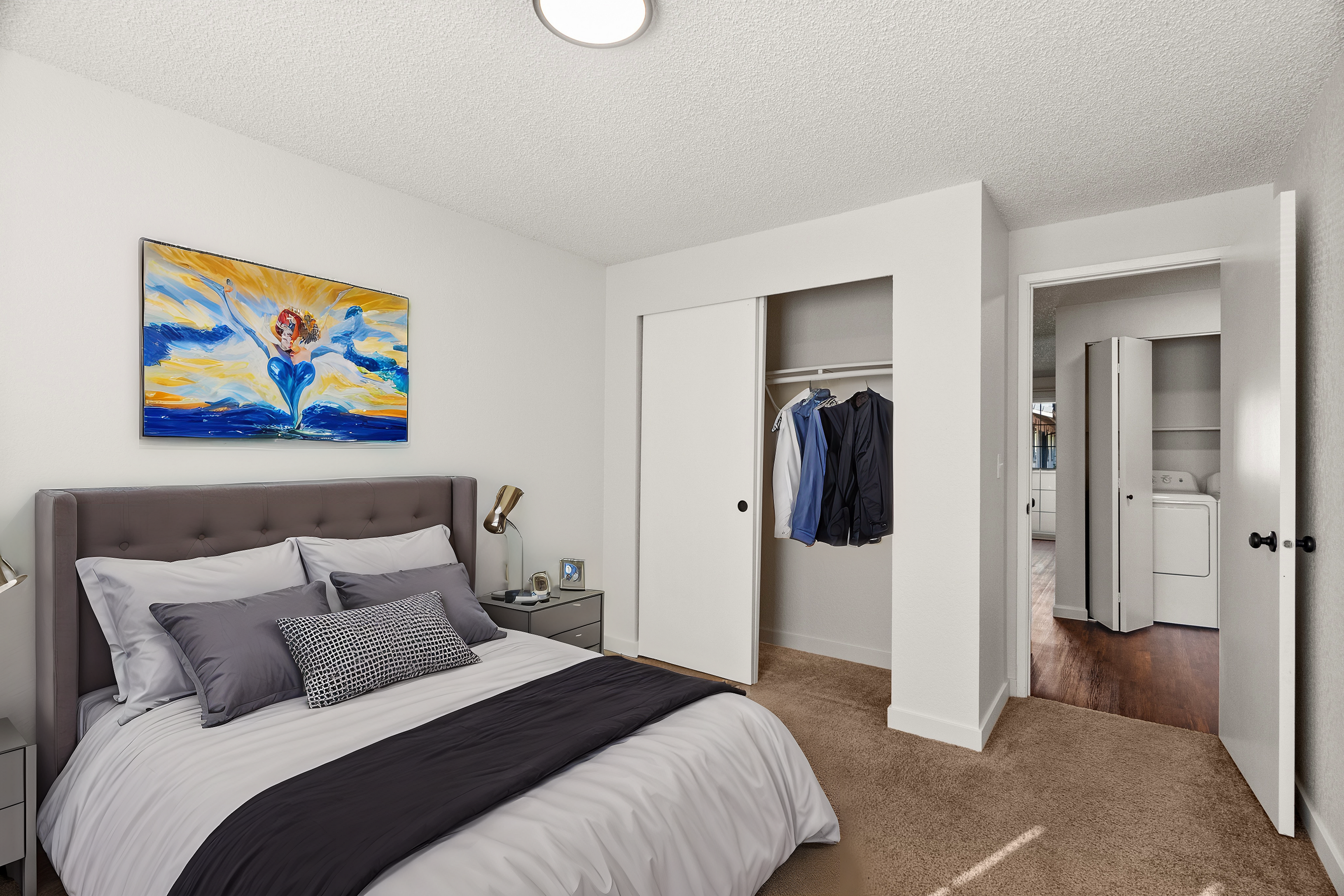 Inviting bedroom with a plush bed, modern artwork, and convenient closet space.