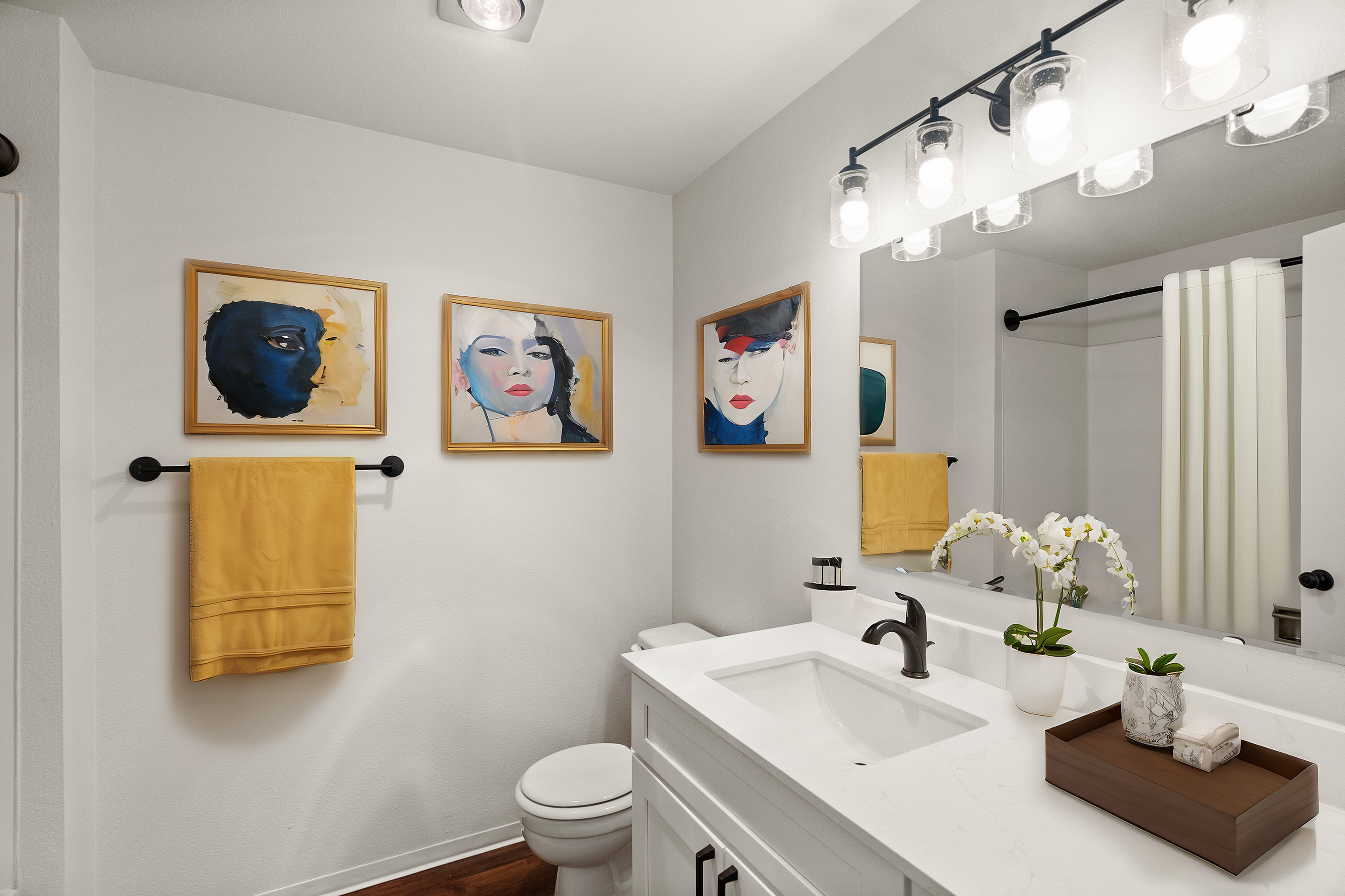 Stylish bathroom with modern artwork, sleek vanity, and elegant lighting fixtures.