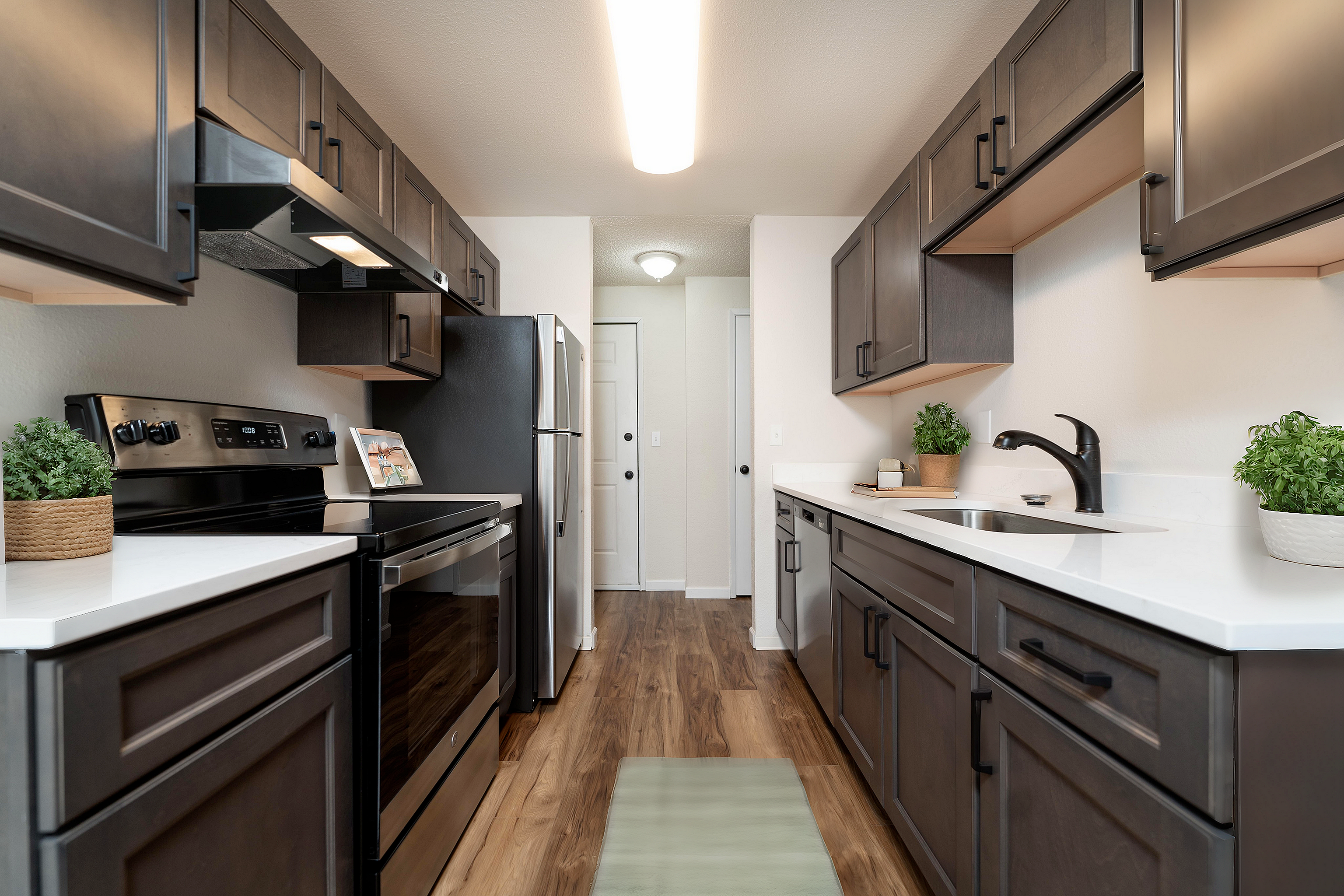 Stylish kitchen with dark cabinetry, stainless steel appliances, and sleek countertops.