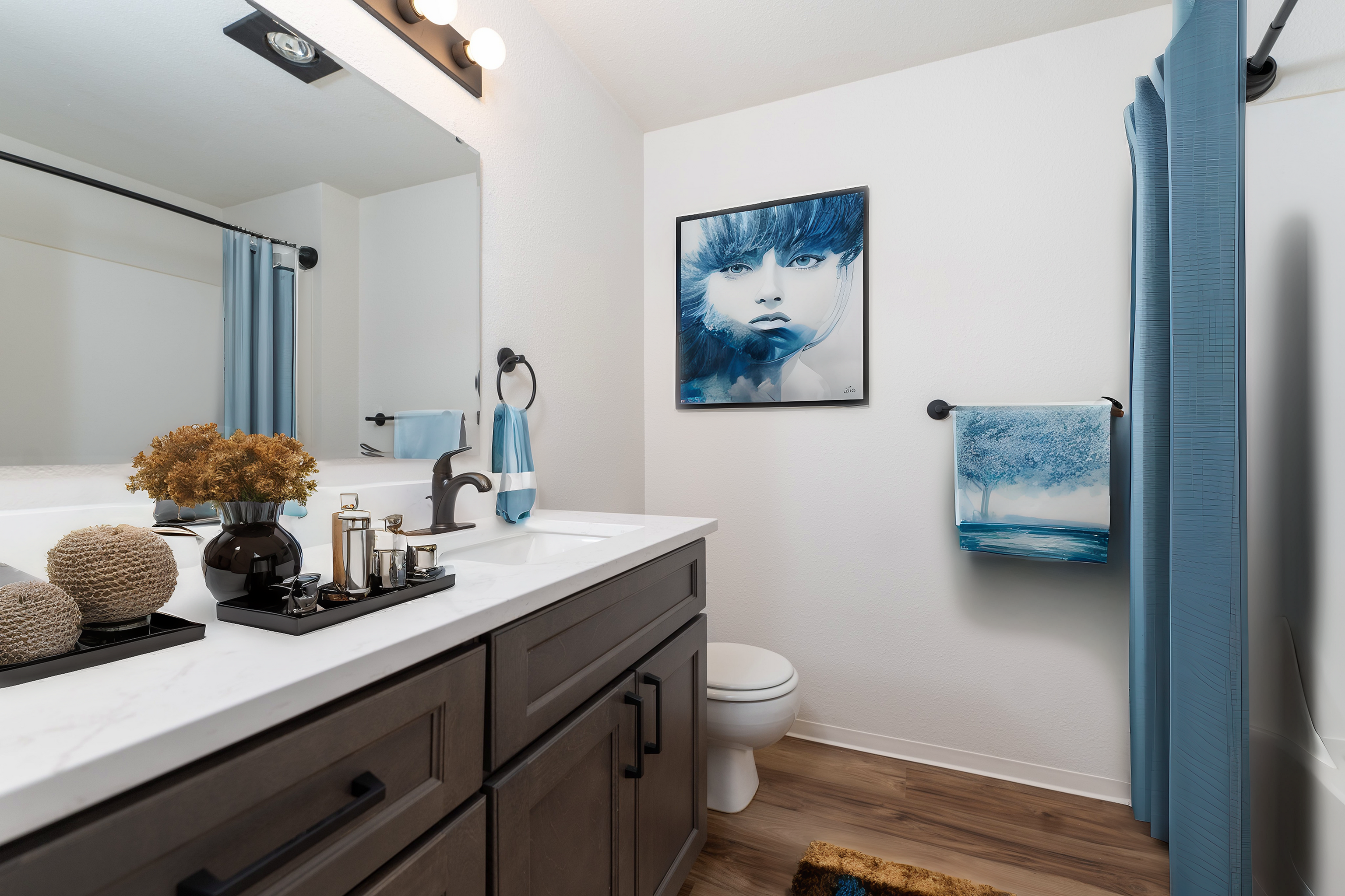 Elegantly designed bathroom with dark wood vanity, modern art, and blue accents.