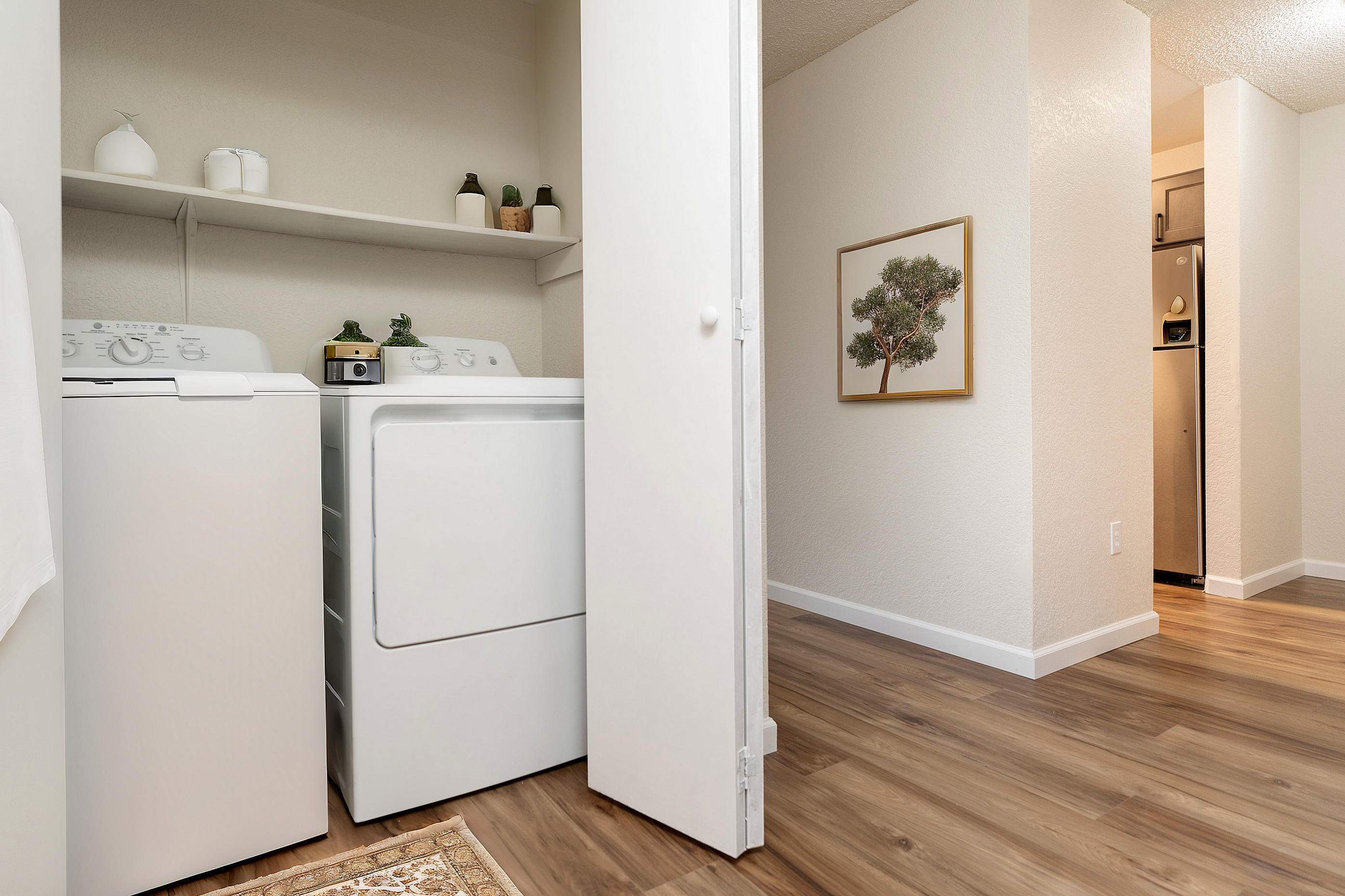 Modern laundry area with washer and dryer, complemented by wooden flooring and minimalistic decor.