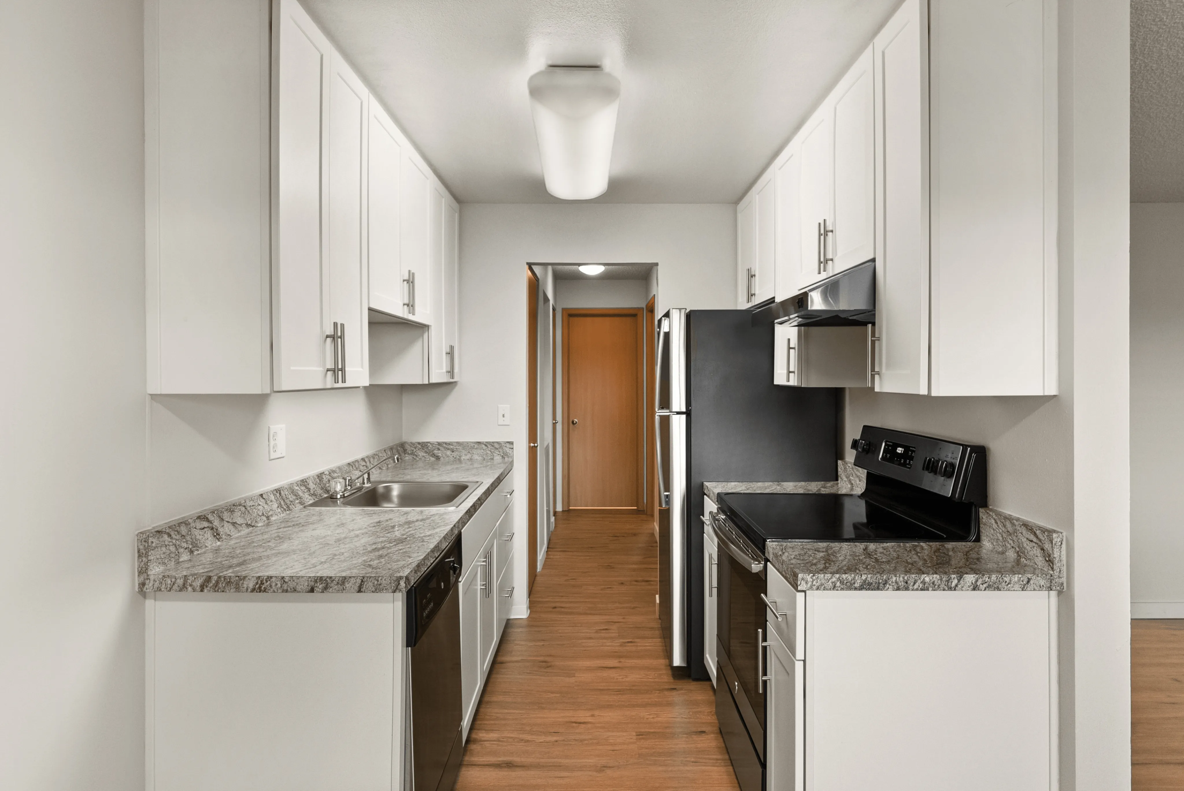 Modern kitchen with sleek white cabinets and stainless steel appliances.