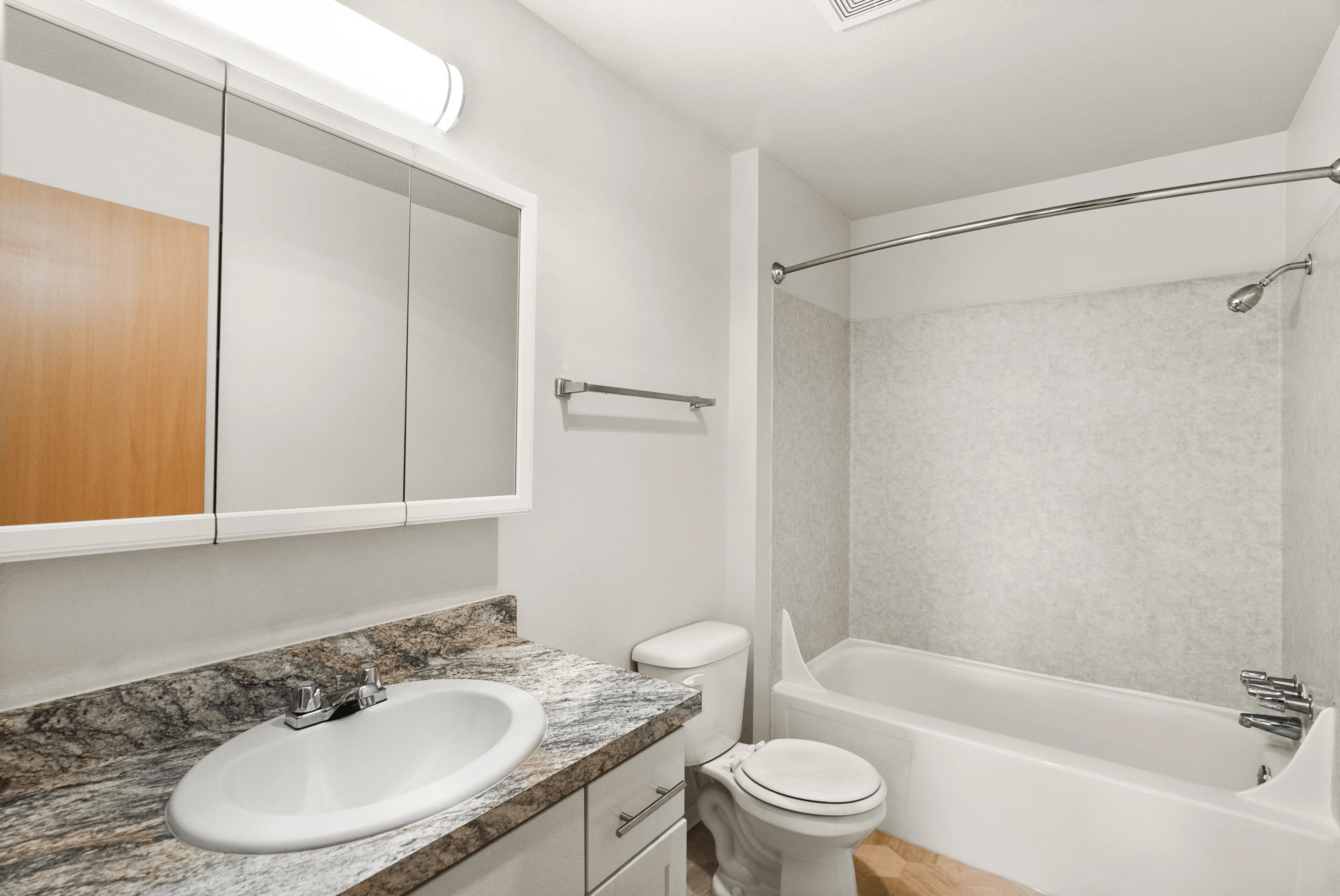 Modern bathroom with a sleek marble countertop, white fixtures, and a spacious bathtub.