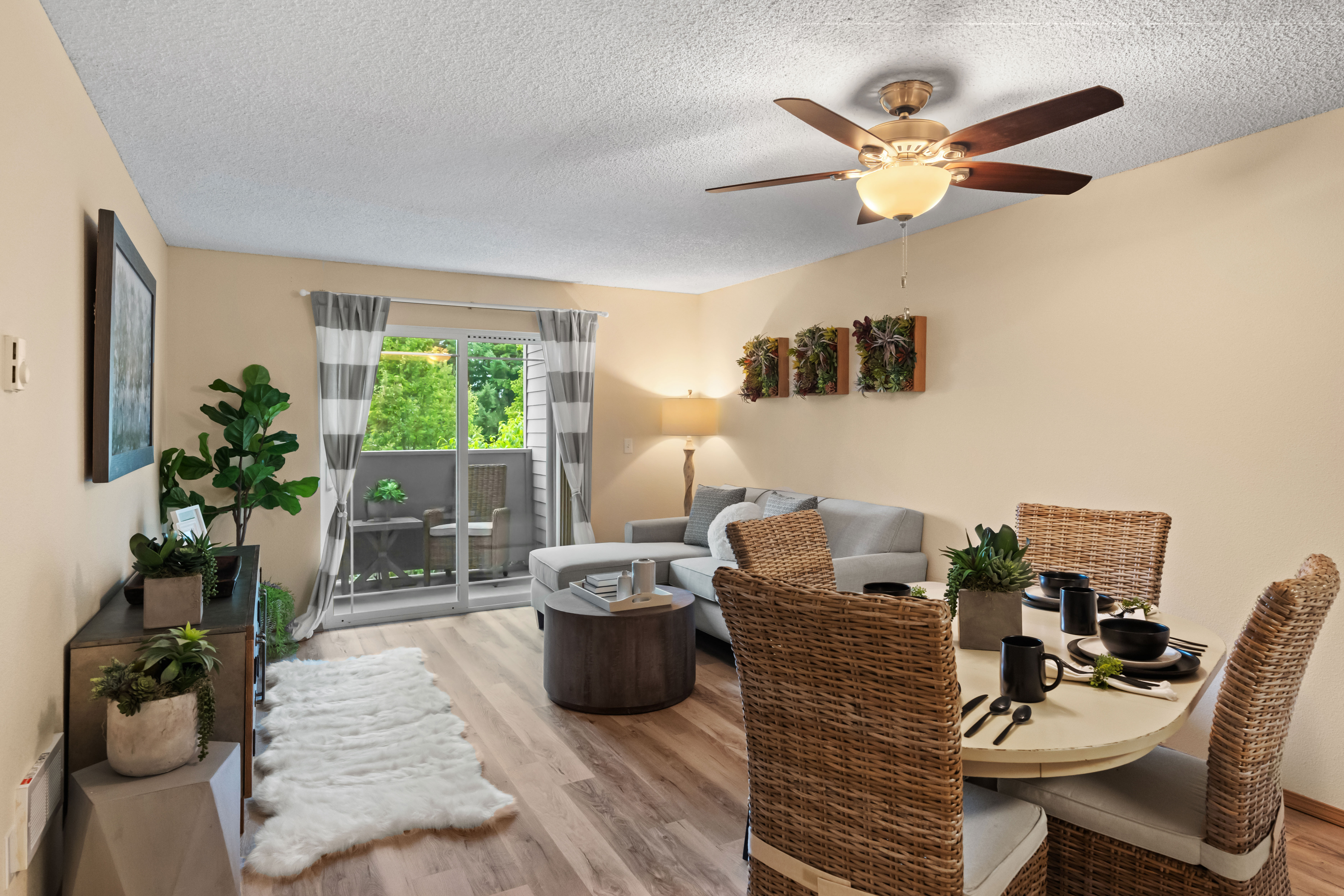 Inviting living room with a cozy sofa, wicker dining set, and balcony view.