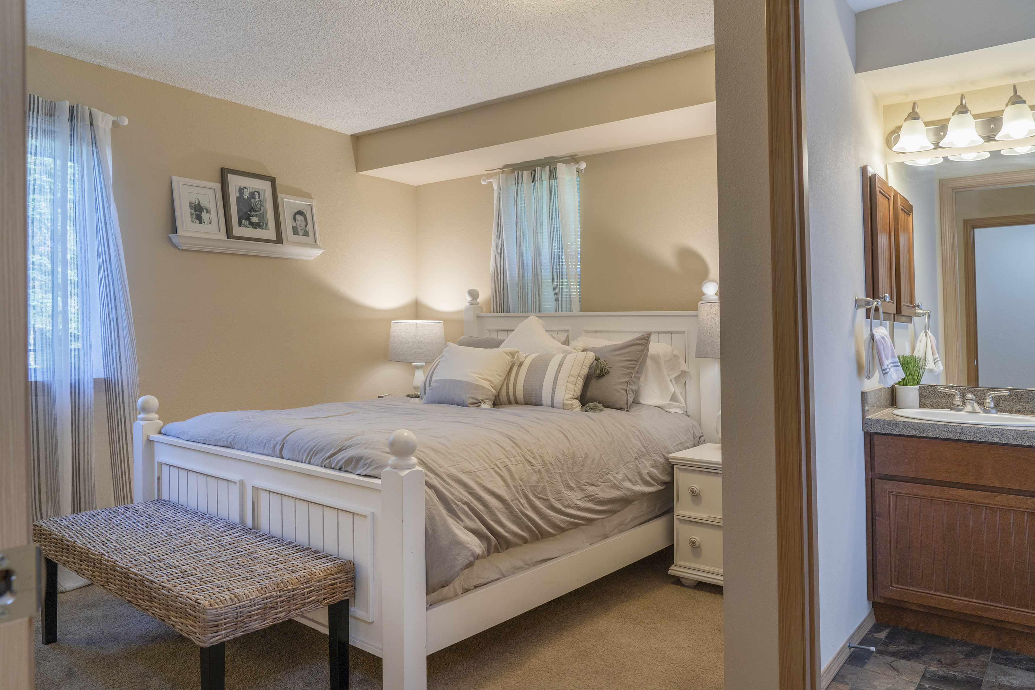 Inviting bedroom with a plush bed, soft lighting, and a connected bathroom.