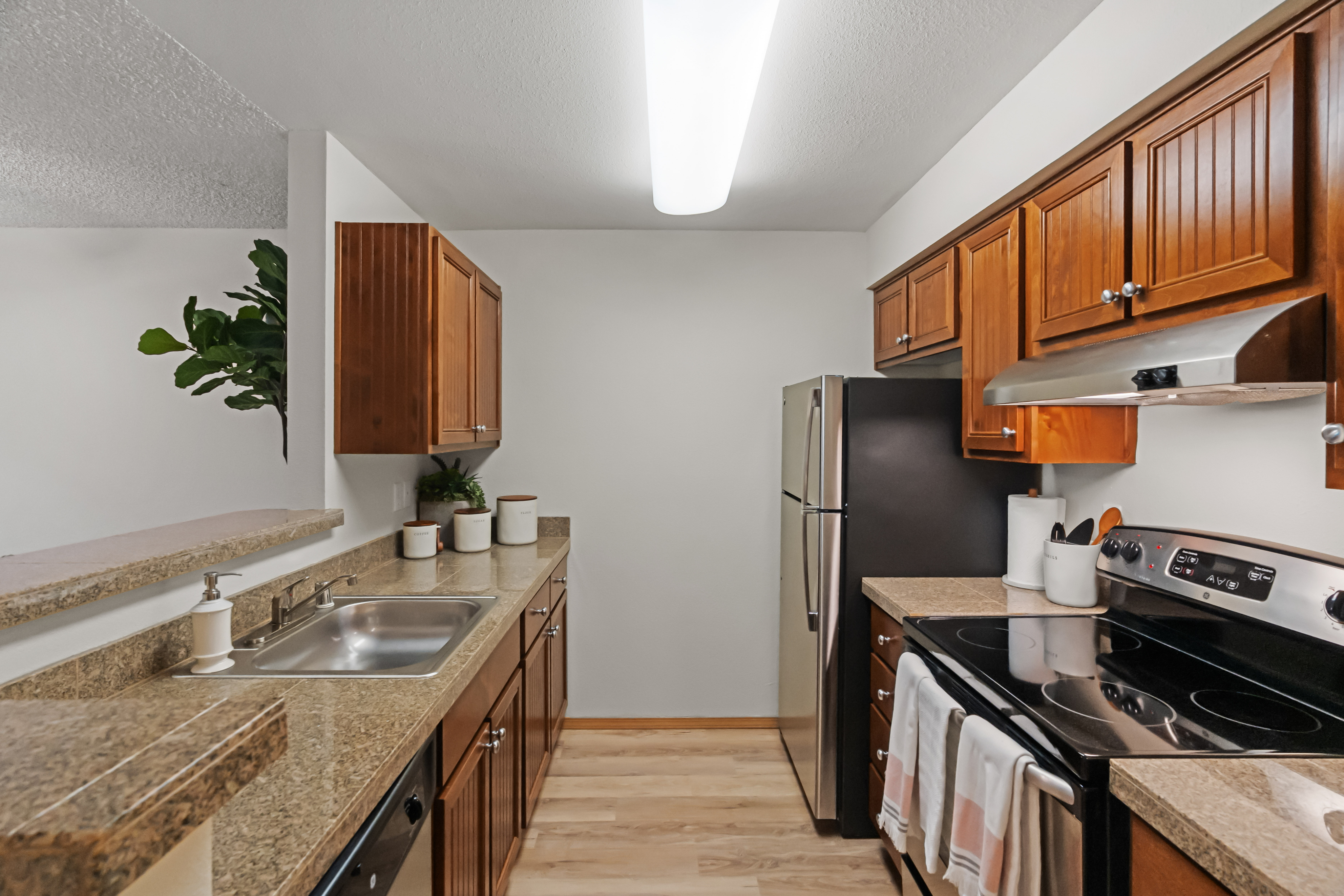 Contemporary kitchen with wooden cabinets, stainless steel appliances, and granite countertops.