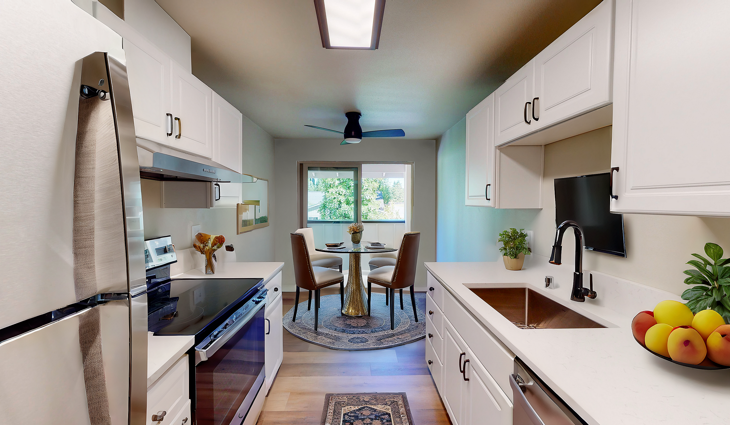 Modern kitchen with white cabinets and a dining area featuring a glass table and elegant chairs.