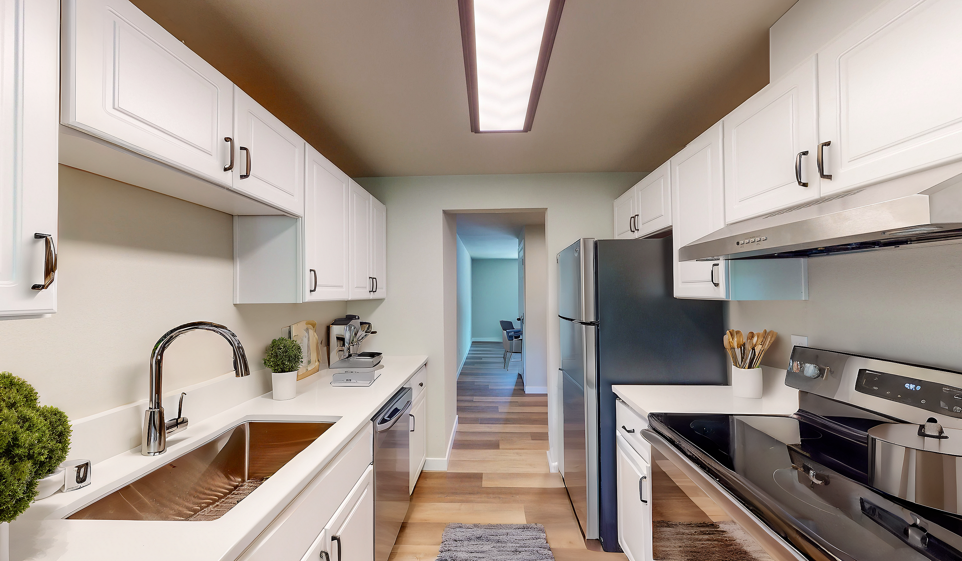 Contemporary kitchen with stainless steel appliances, elegant white cabinetry, and stylish lighting.