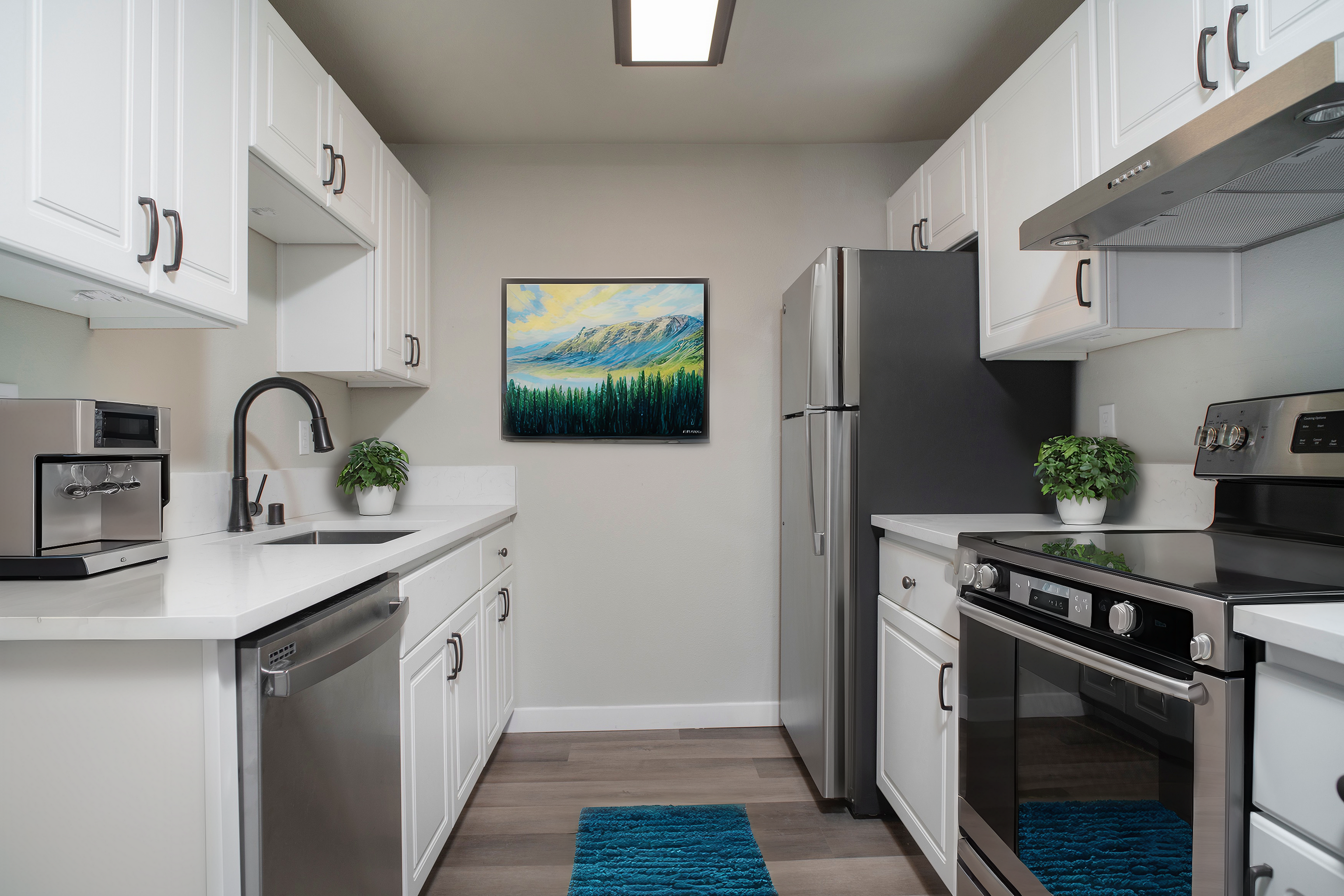 Contemporary kitchen with stainless steel appliances, white cabinets, and elegant decor.
