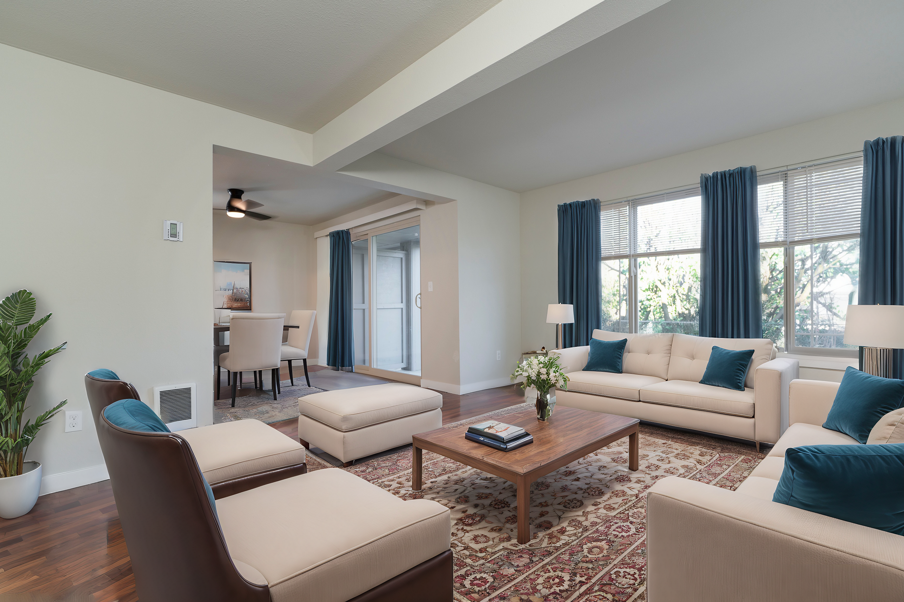 Bright and inviting living room with modern furniture and large windows, adjacent to a cozy dining area.