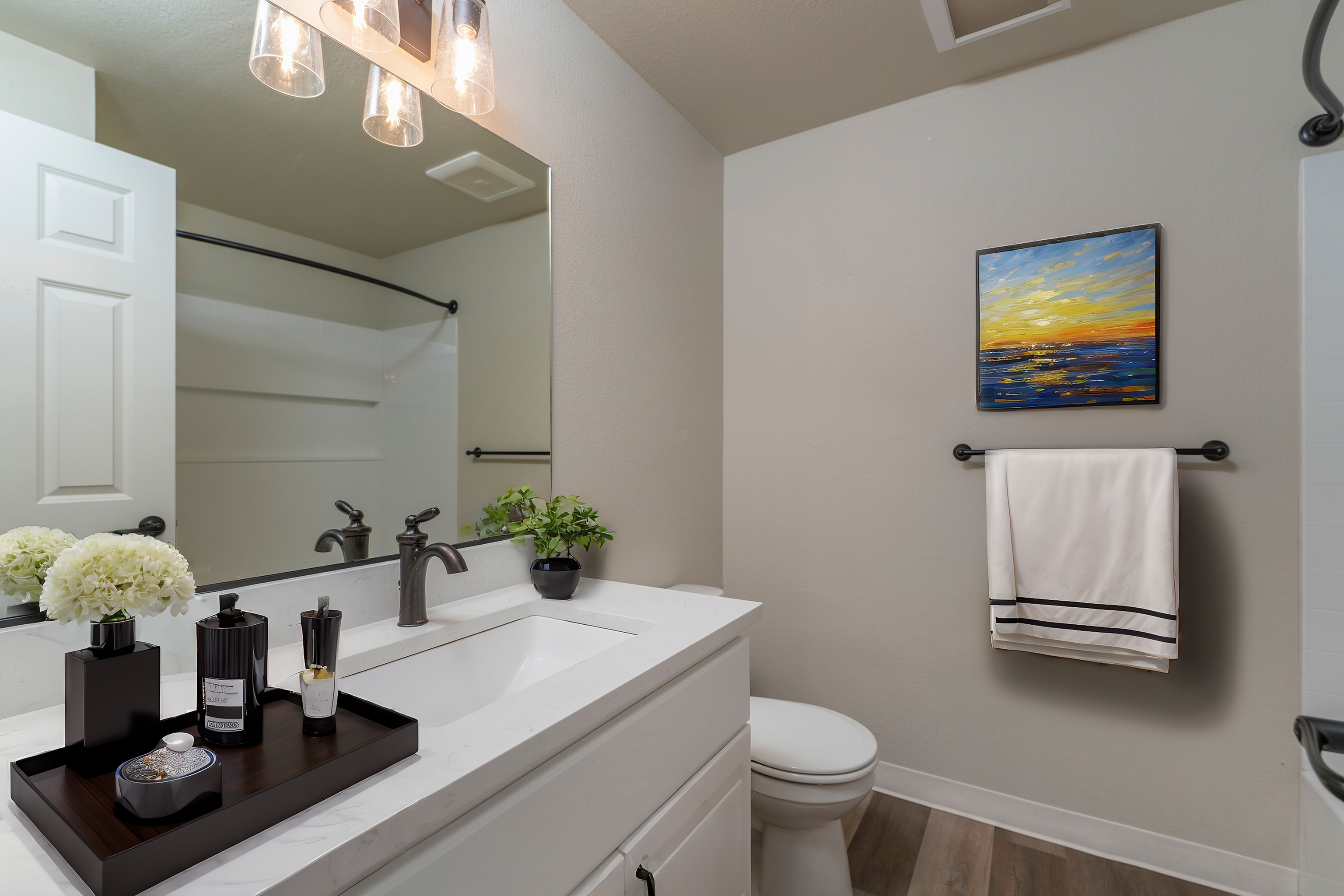 Elegant bathroom with modern fixtures, a large mirror, and art decor.