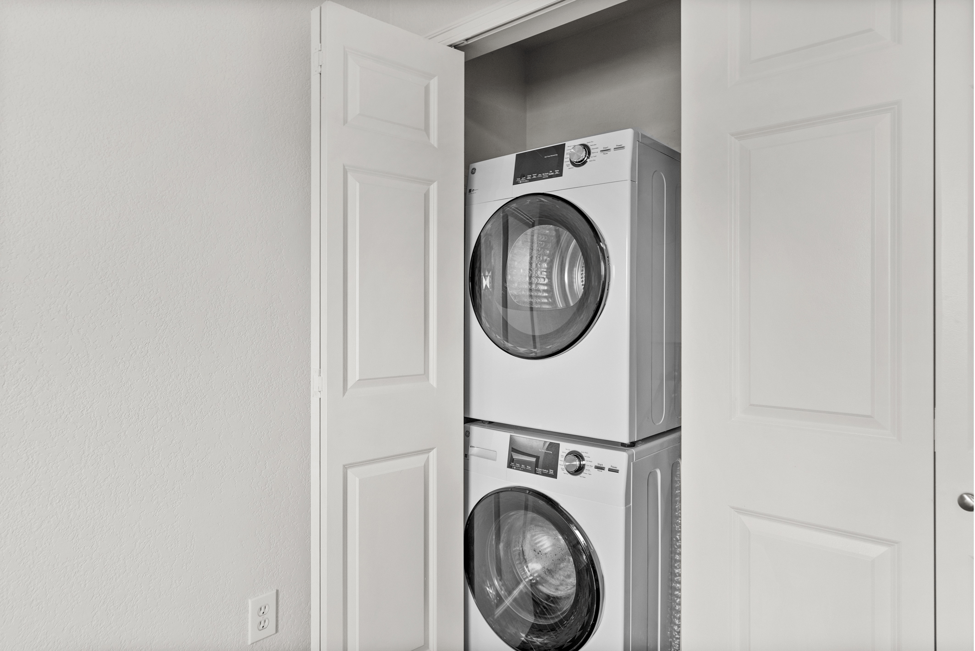 Compact laundry area featuring a stackable washer and dryer within a neat closet space.