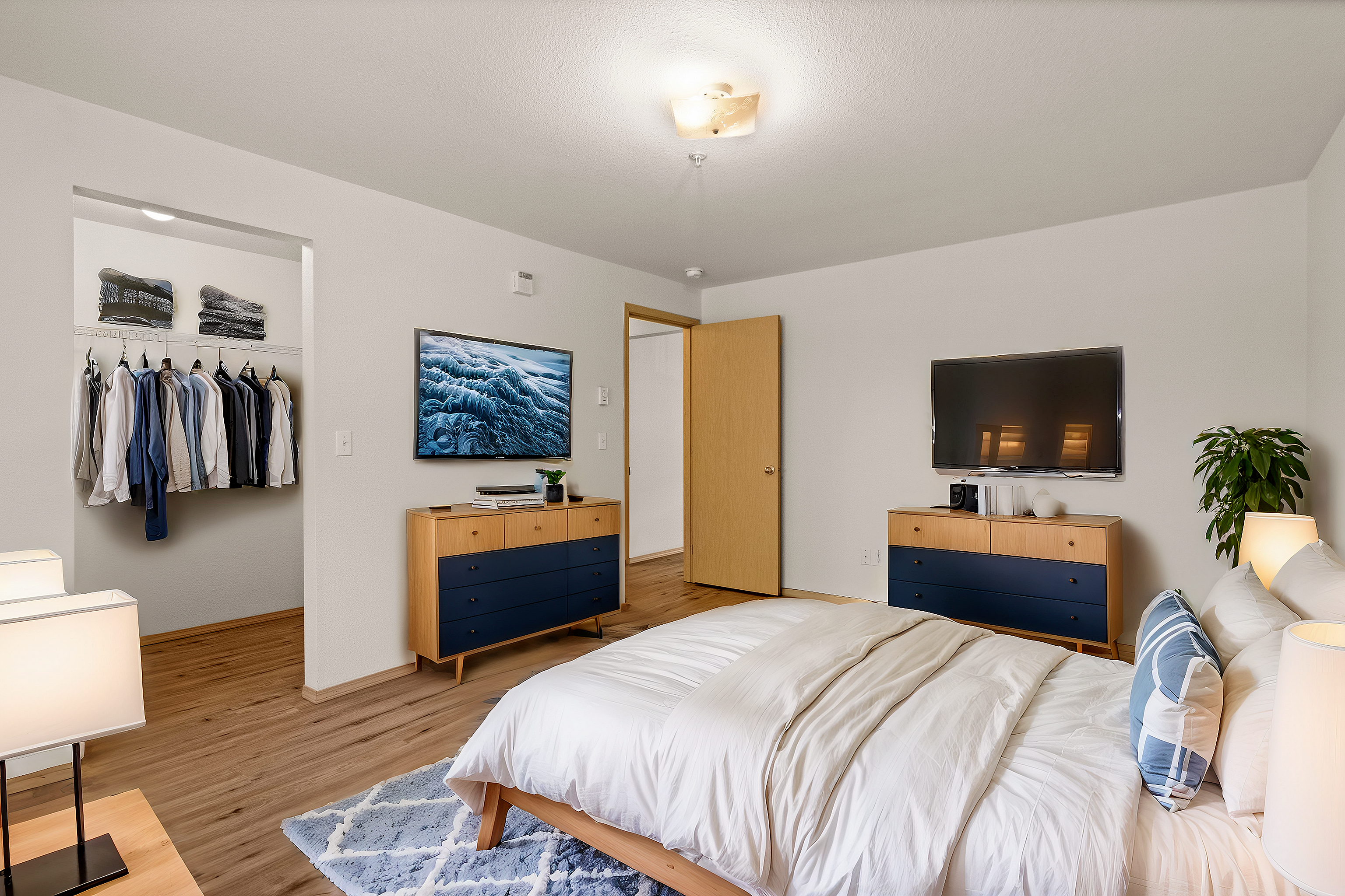 Spacious bedroom with modern decor, a double bed, wooden furniture, and a wall-mounted TV.