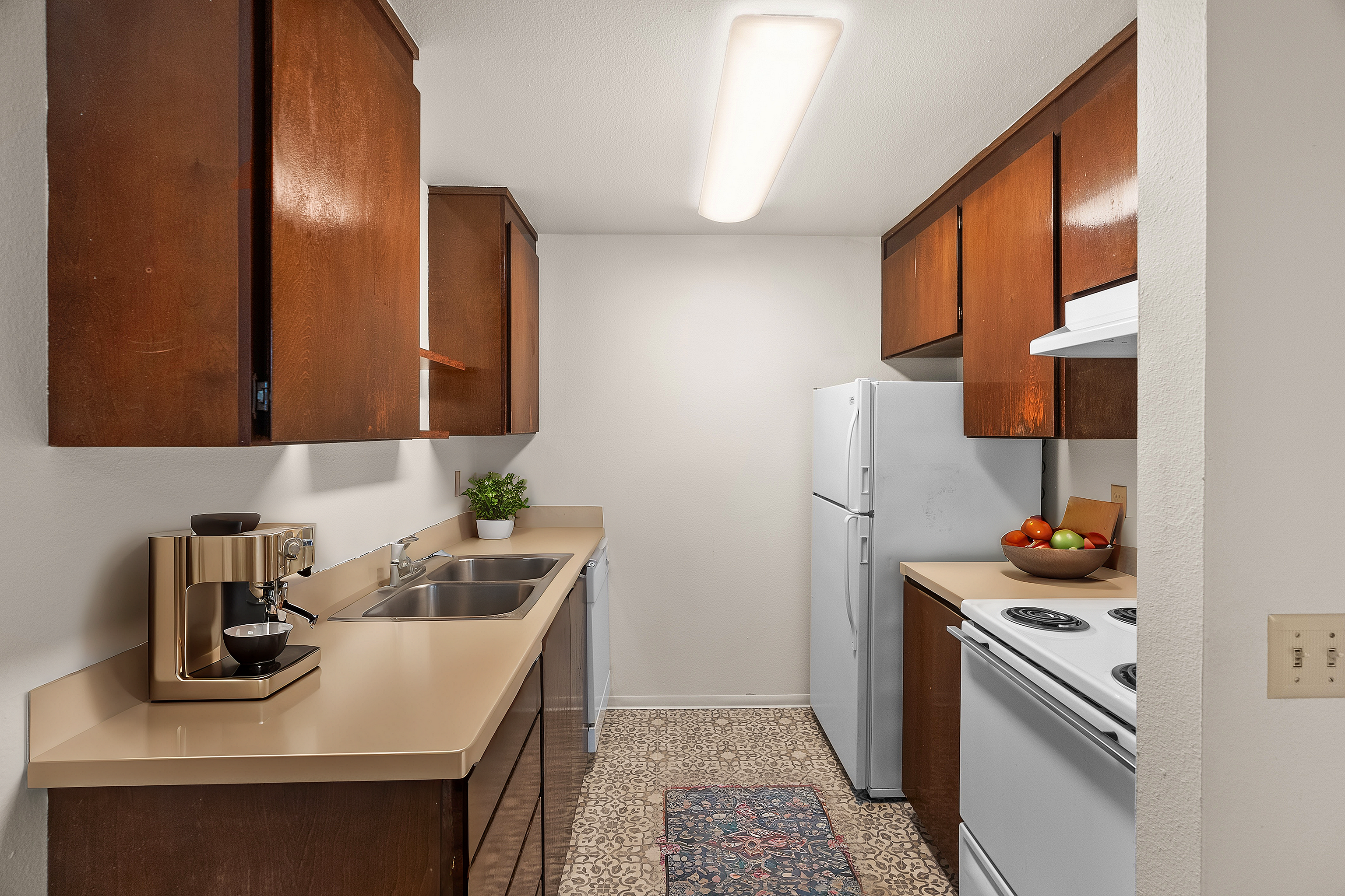 Cozy kitchen with warm wood cabinetry, modern appliances, and elegant lighting, perfect for culinary creativity.