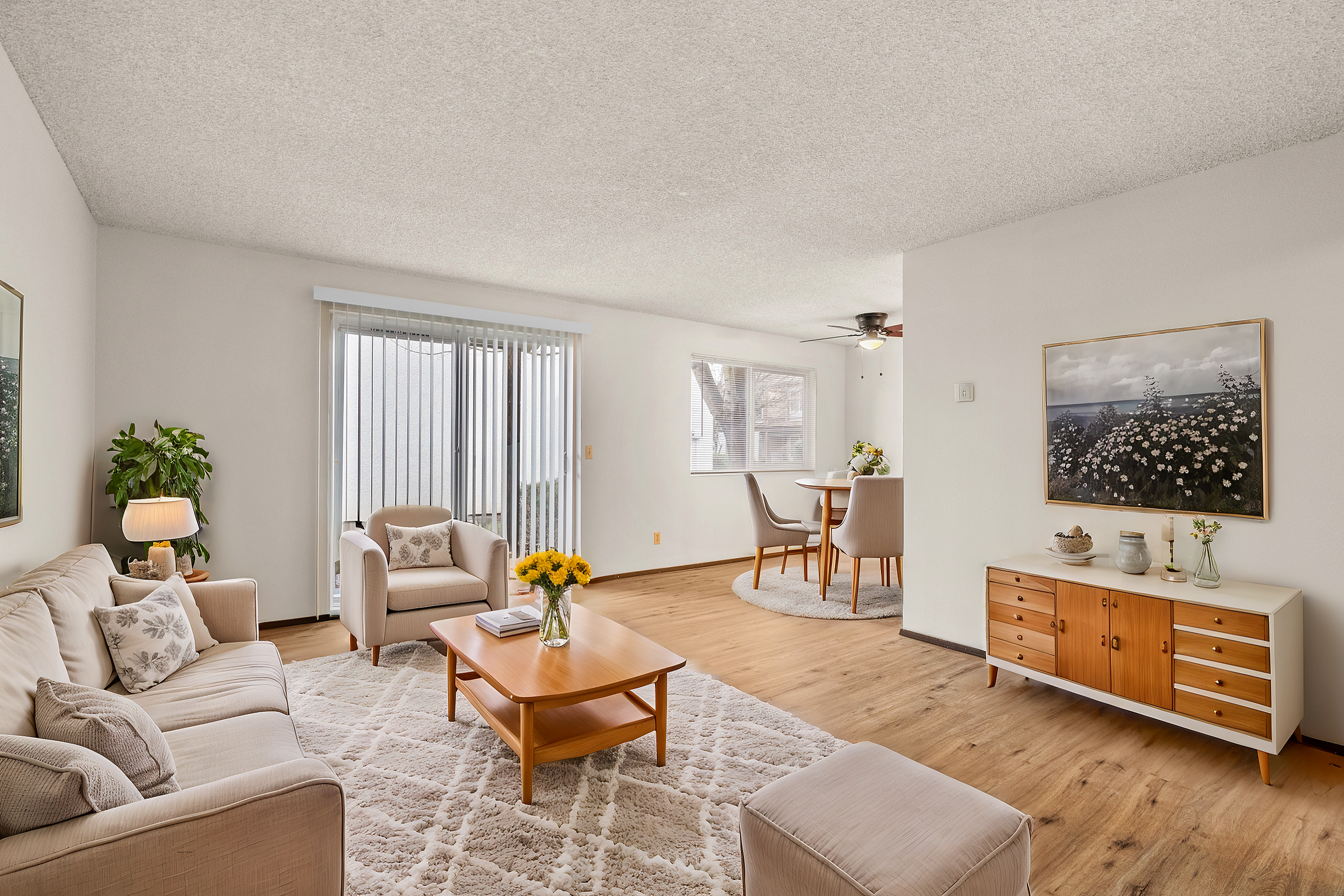 Bright and inviting living room with stylish decor, featuring a cozy sofa, elegant armchair, and wooden coffee table. Adjacent is a charming dining area with a modern table and chairs, complemented by a scenic window view.