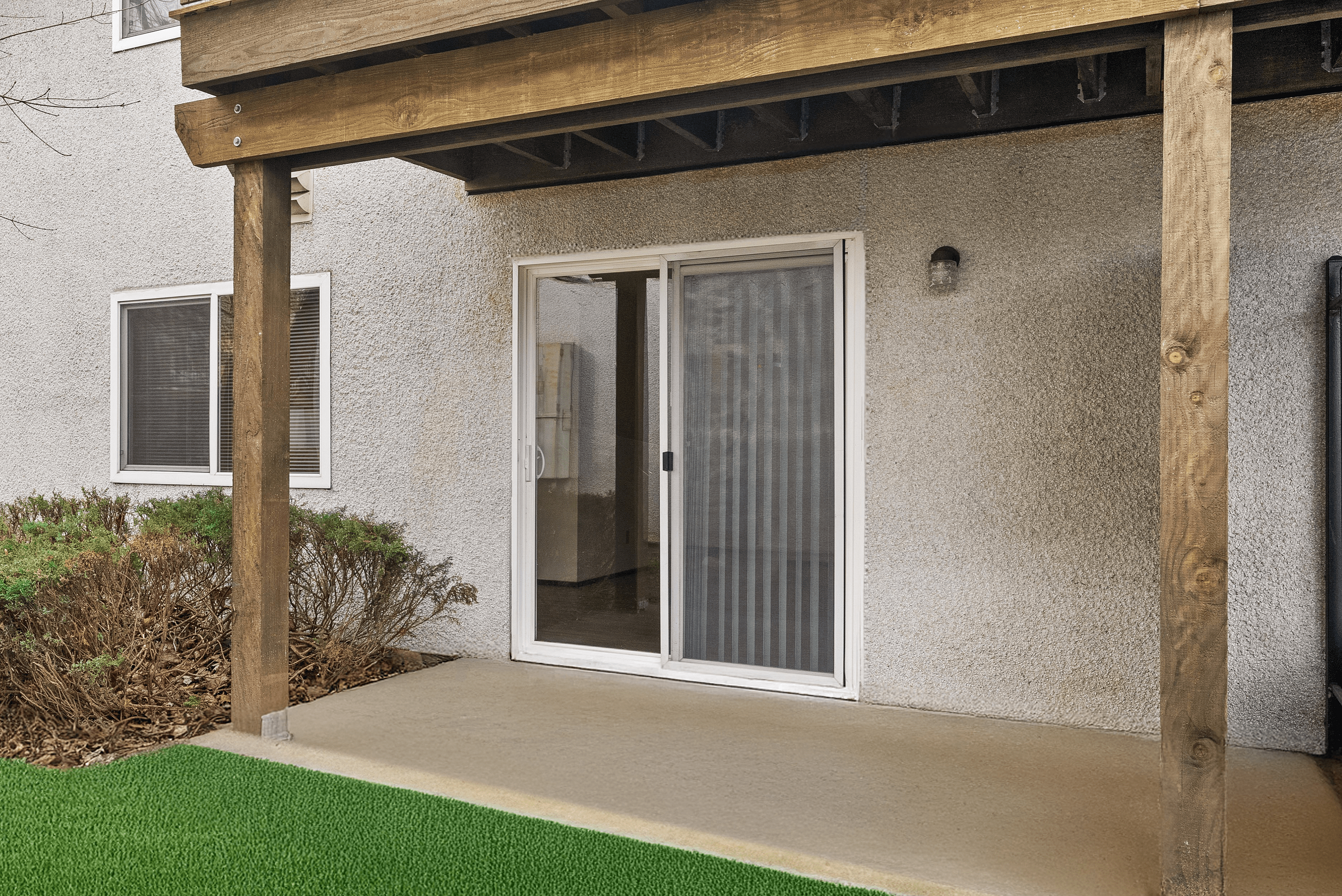 Inviting patio space with sliding glass doors and lush green lawn accents, perfect for relaxation and outdoor enjoyment.