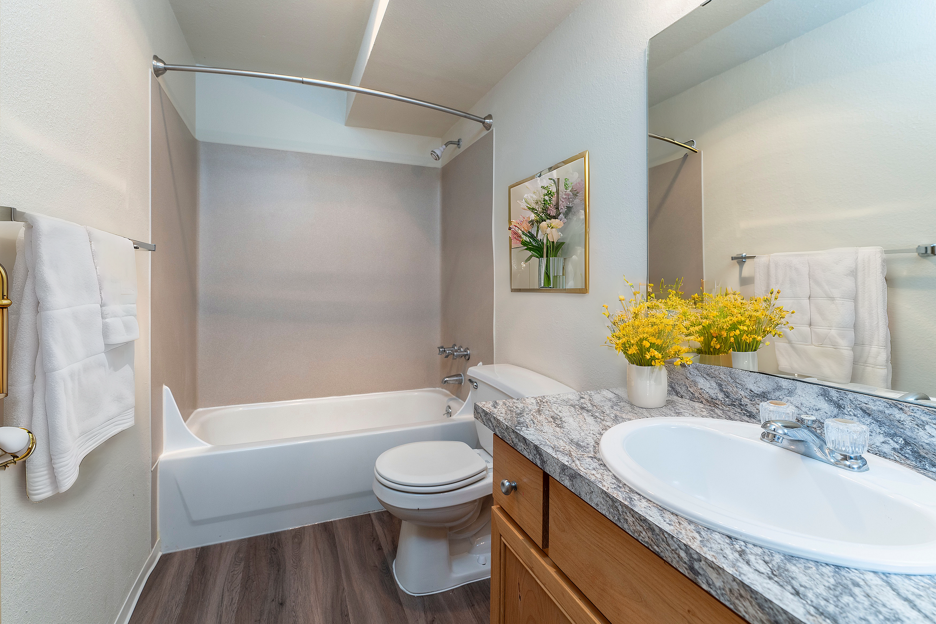 Elegant bathroom with modern amenities, featuring a sleek granite countertop, stylish cabinetry, and vibrant floral decor.