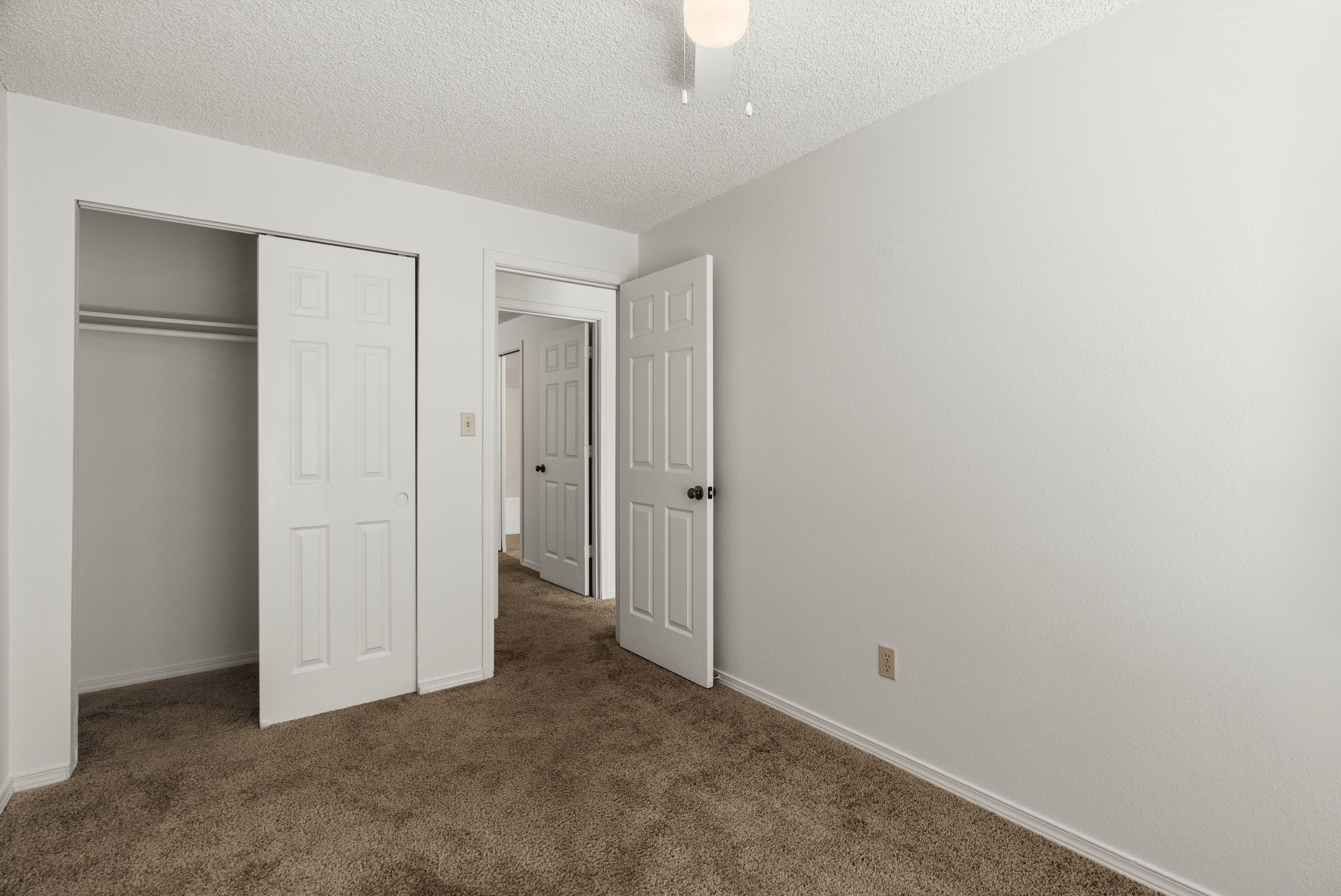 Inviting bedroom with plush carpeting, ample closet space, and modern panel doors.