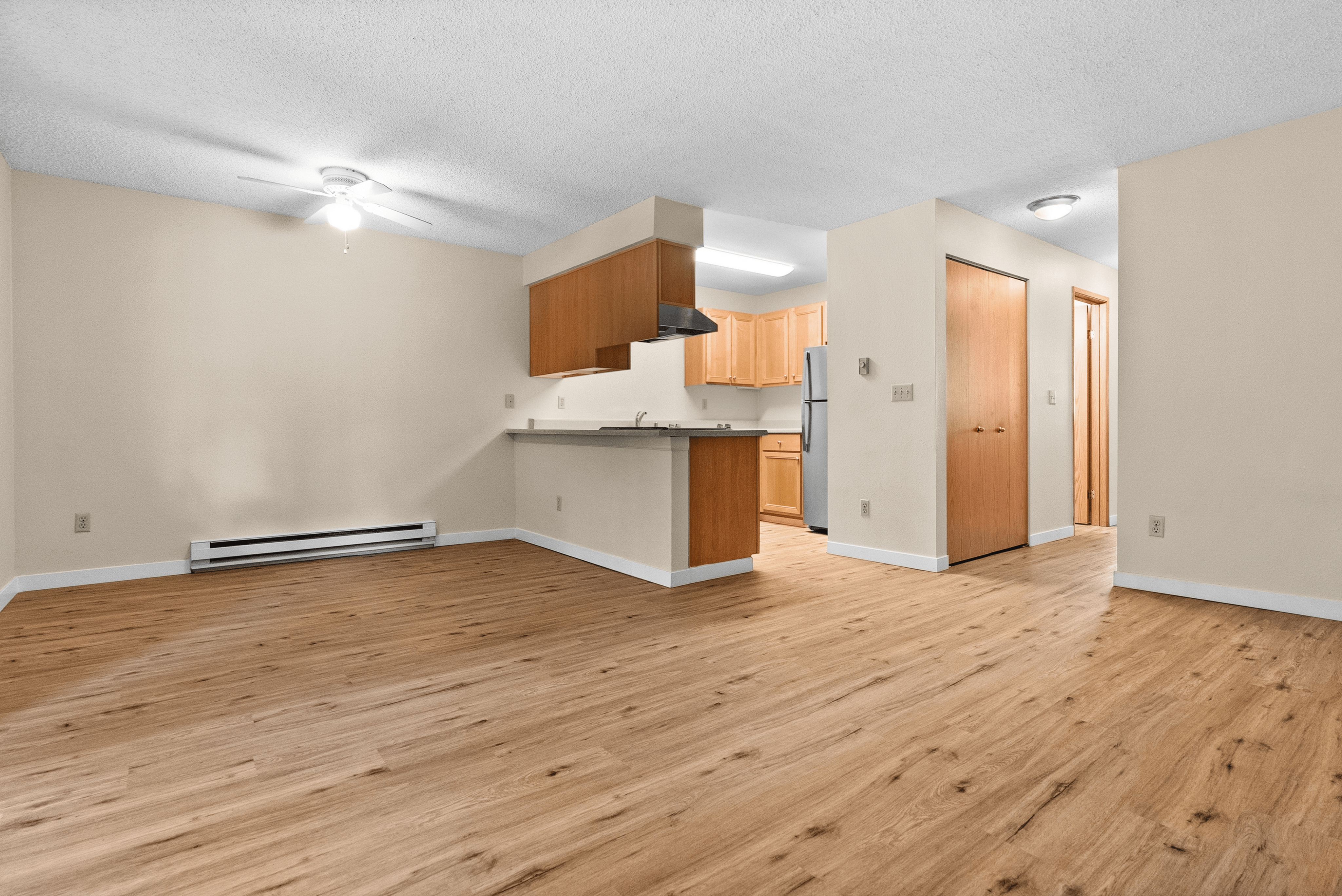 Modern apartment with wood flooring and stainless steel appliances.