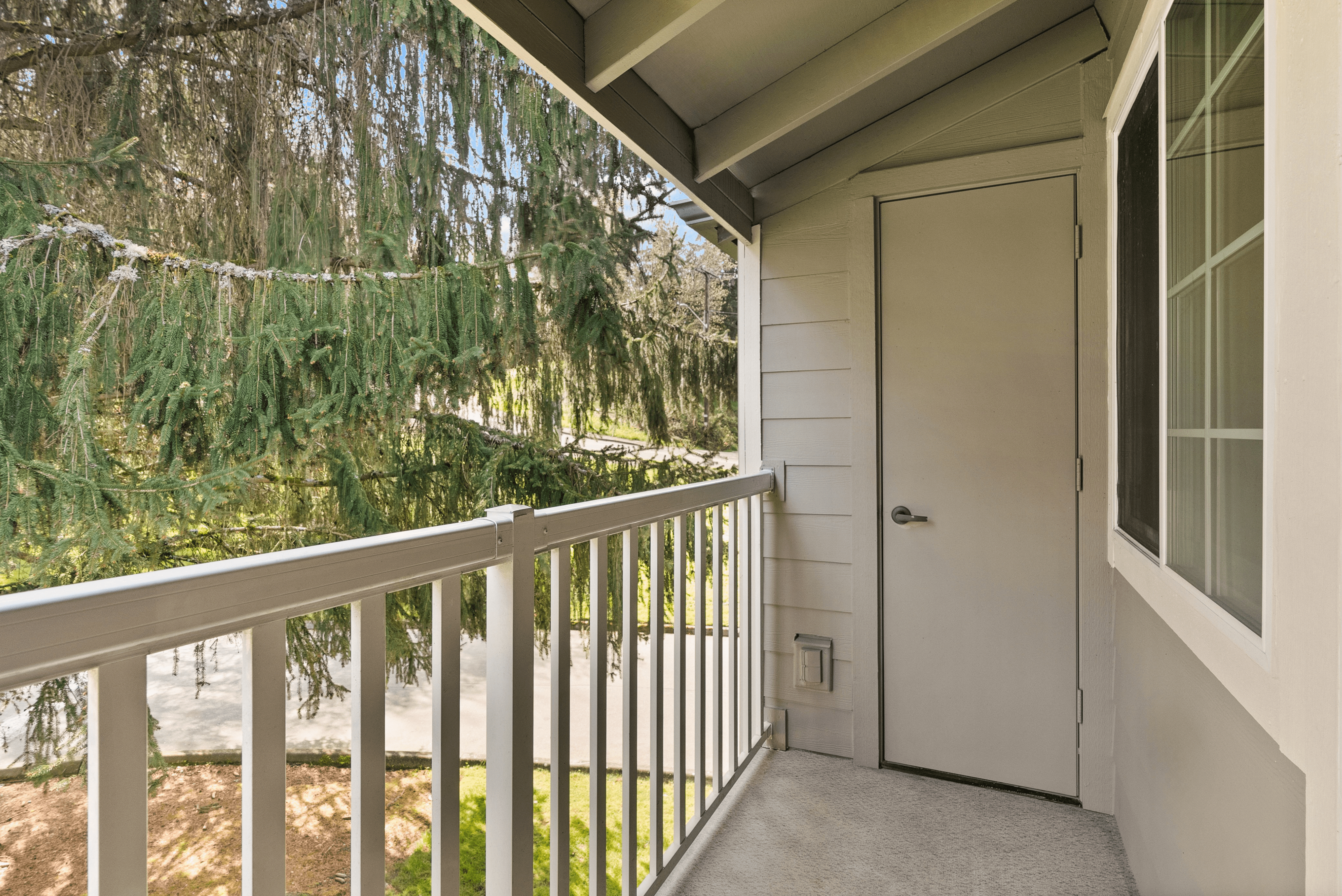 Balcony with additional storage and scenic view of the greenery in the community.