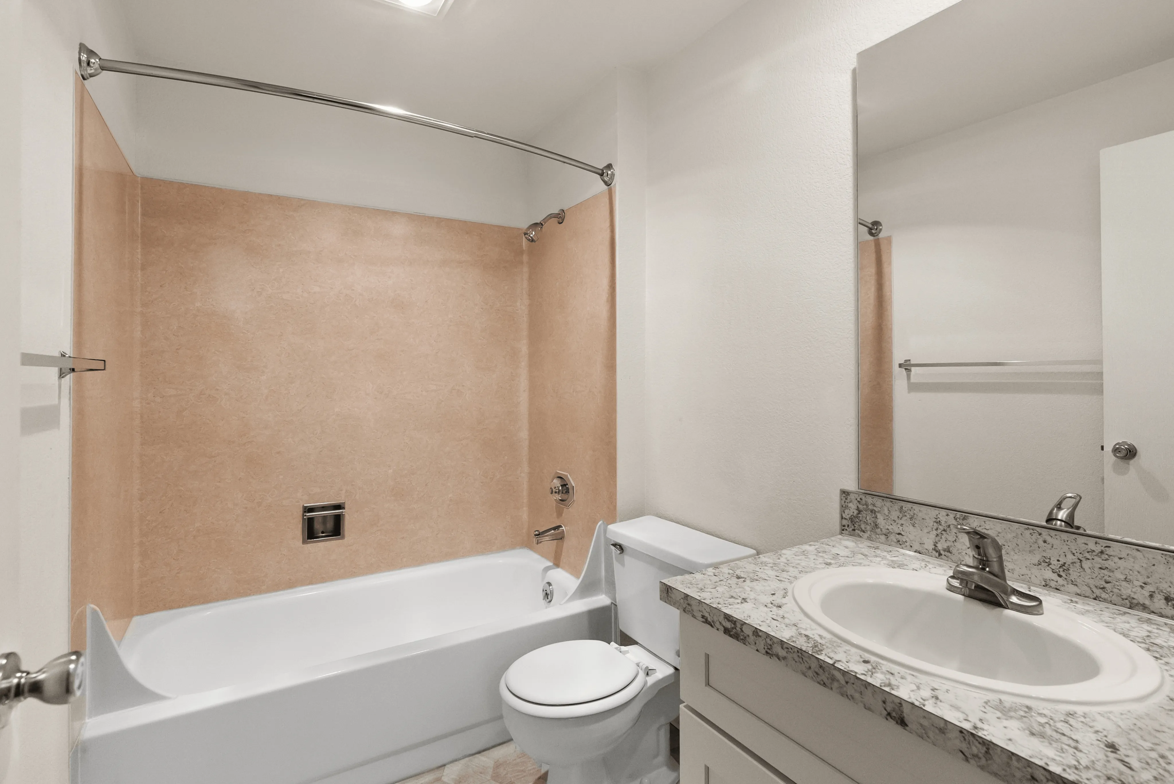Modern bathroom featuring a luxurious bathtub, elegant marble countertop with sink, and sleek fixtures.