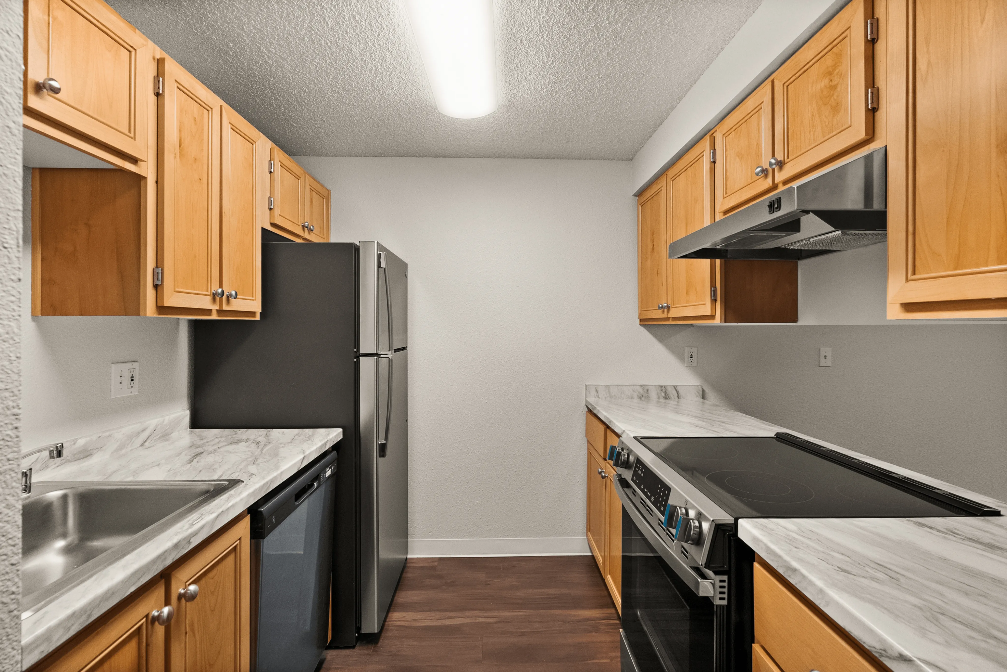 Modern kitchen with sleek stainless steel appliances, elegant wood cabinetry, and marble countertops.