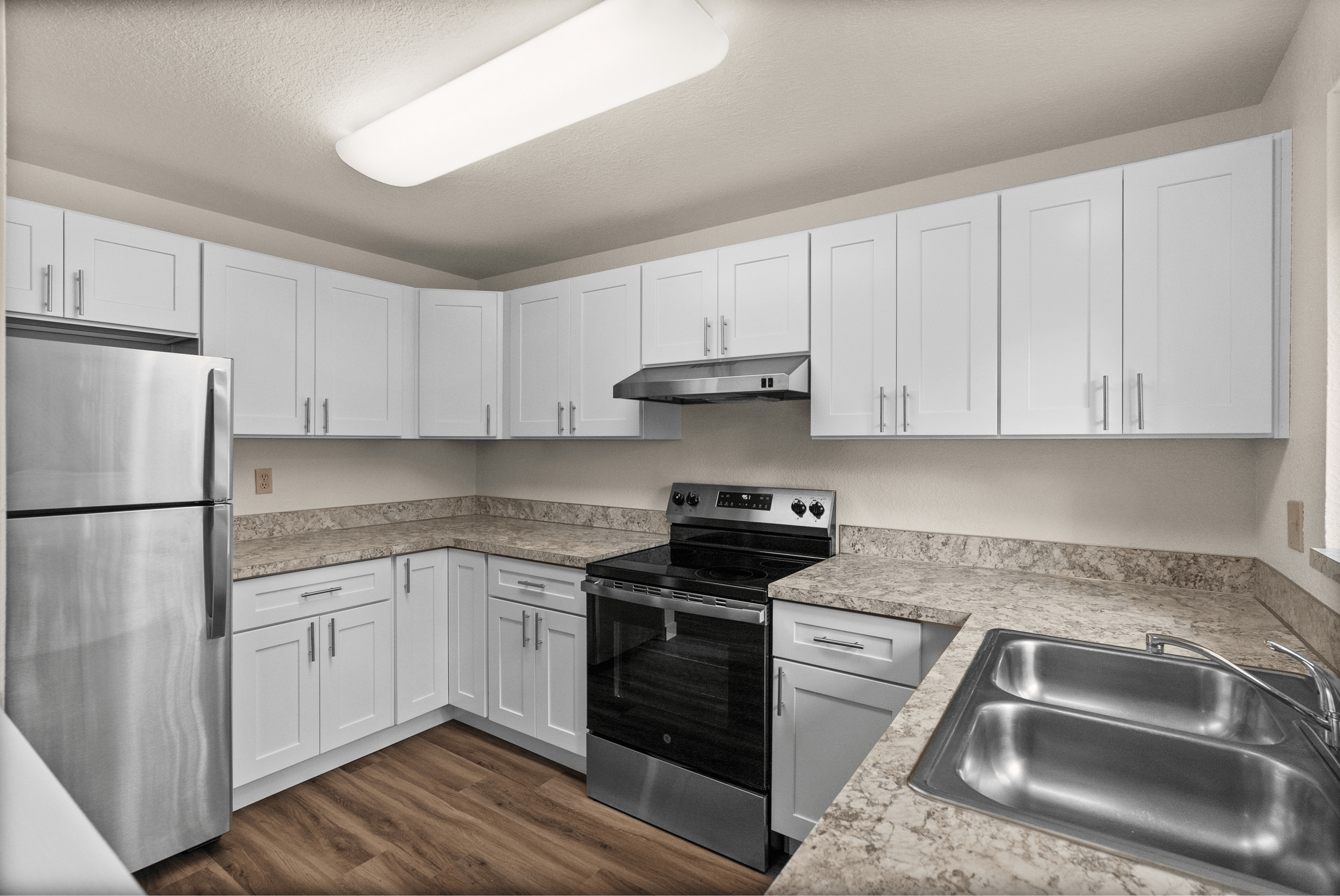 Modern kitchen with sleek stainless steel appliances, elegant white cabinetry, and polished countertops.