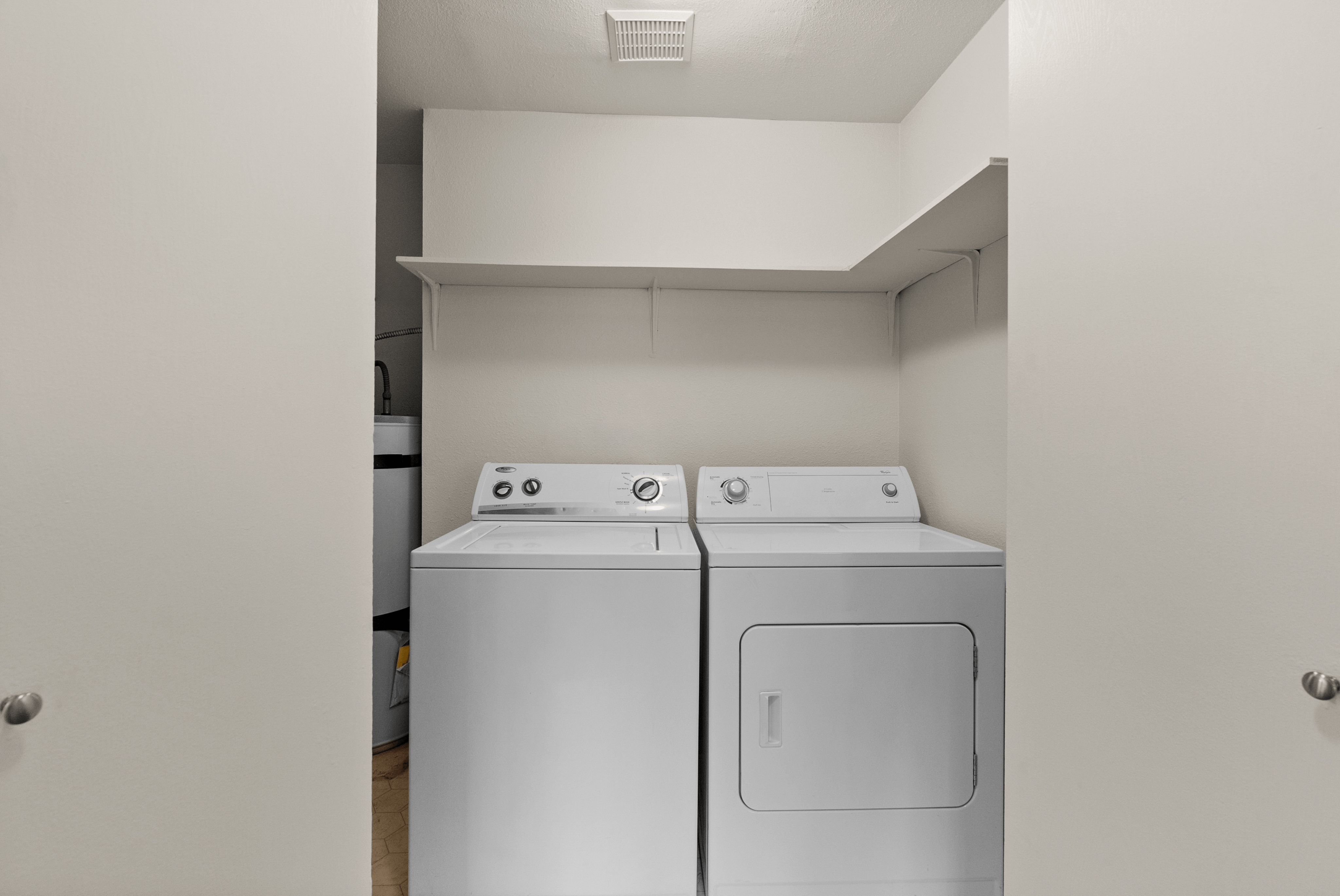Convenient in-unit laundry with modern washer and dryer in a bright, organized space.