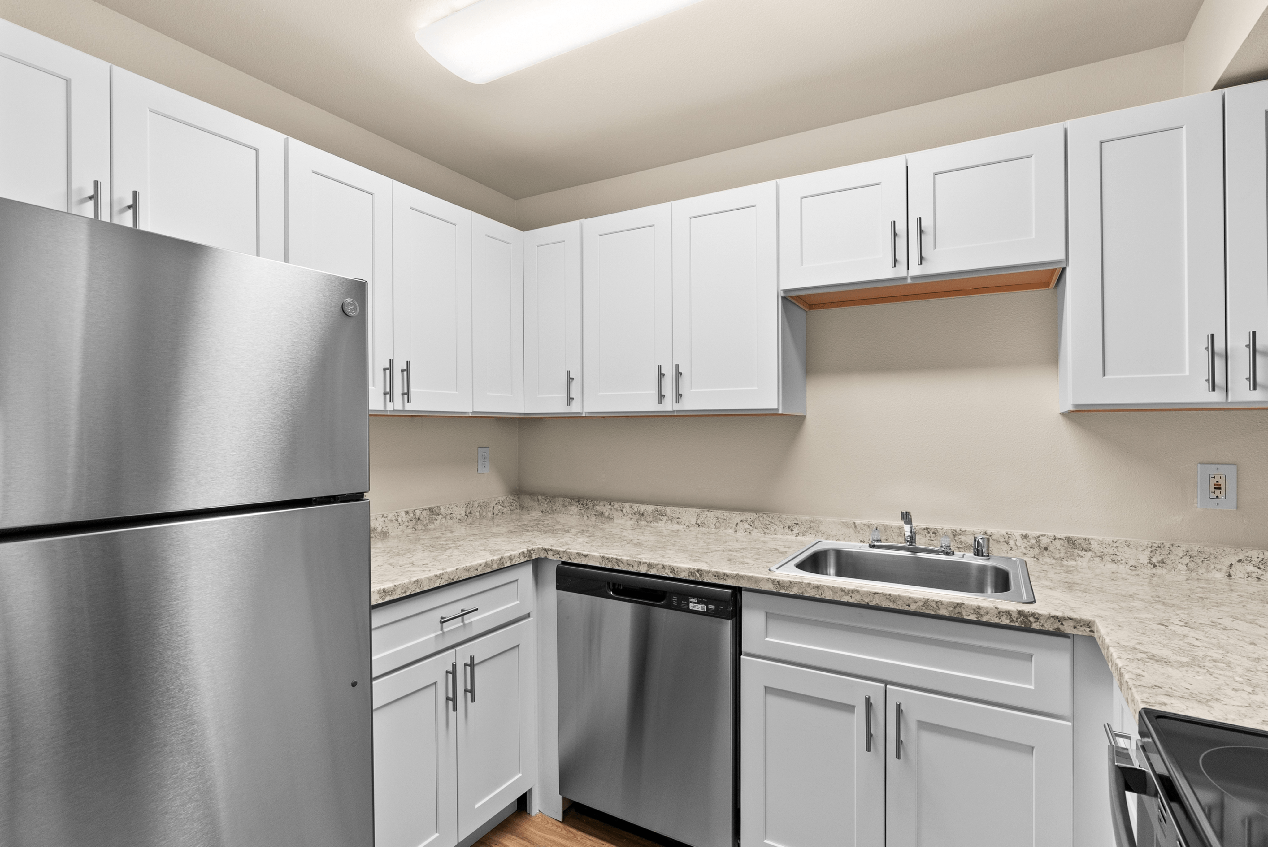 Modern kitchen showcasing sleek stainless steel appliances, elegant granite countertops, and stylish white cabinetry for a contemporary feel.