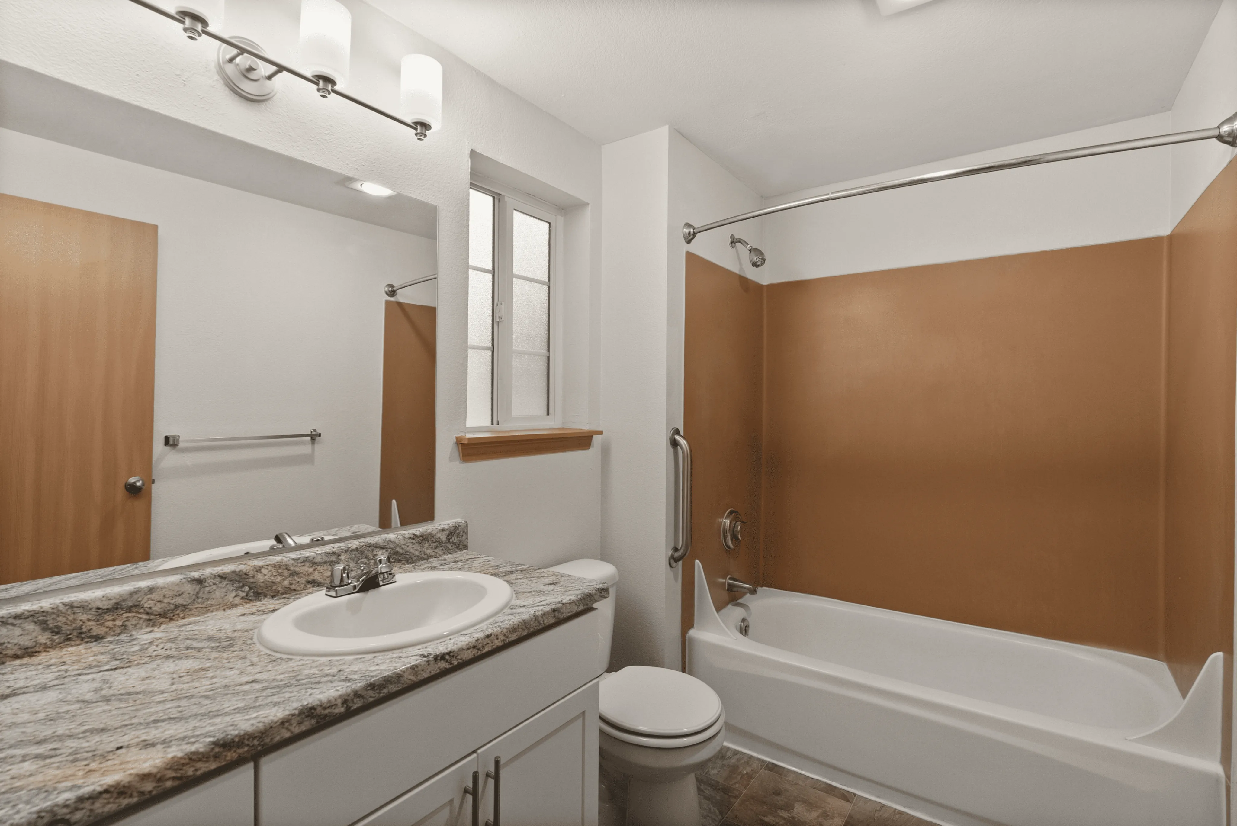 Elegant bathroom featuring a granite countertop, modern fixtures, and a chic brown accent wall.