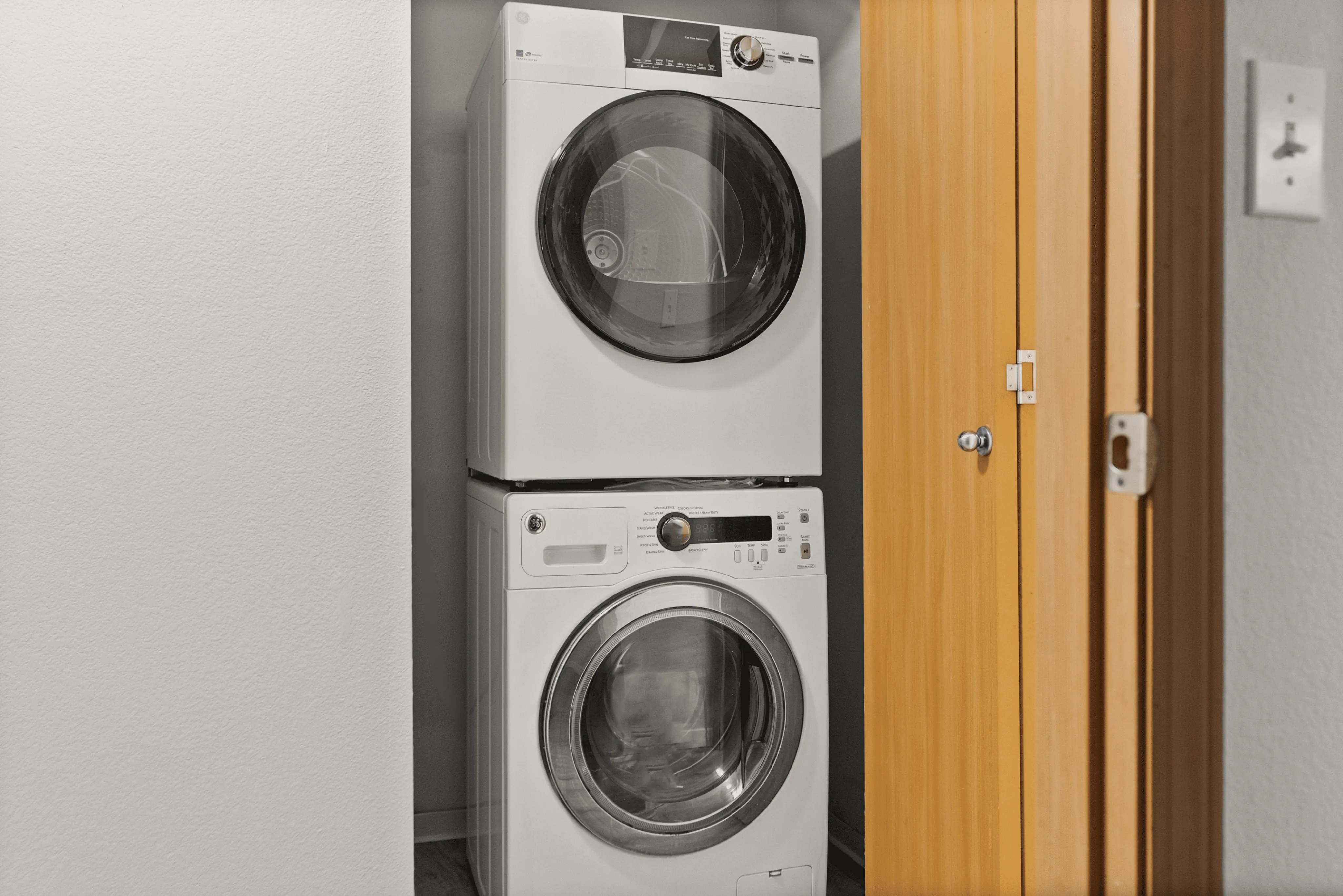 Compact laundry nook featuring a sleek stacked washer and dryer set, perfect for modern living spaces.