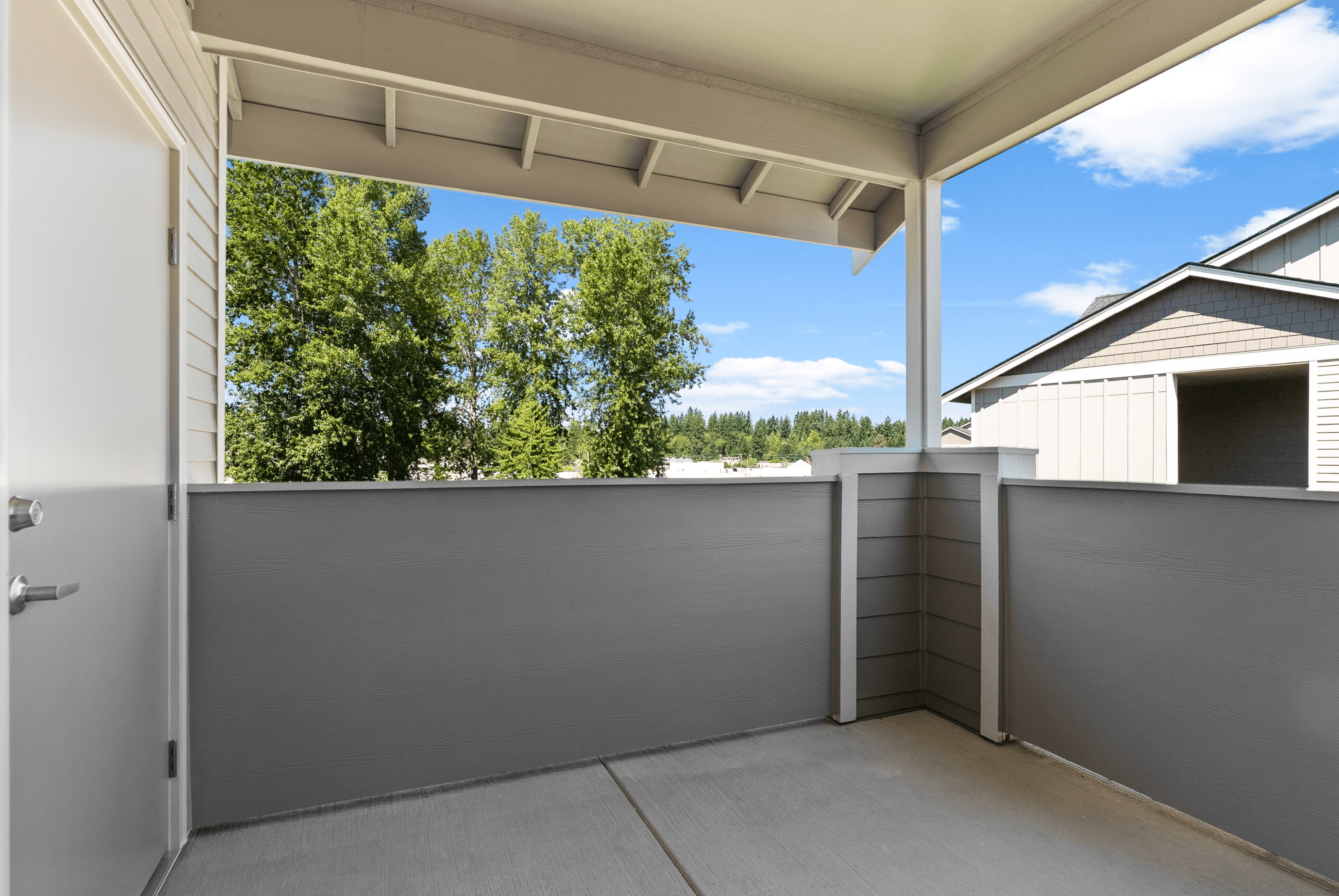 Inviting balcony with serene views of lush trees and blue skies, perfect for relaxing in a peaceful setting.