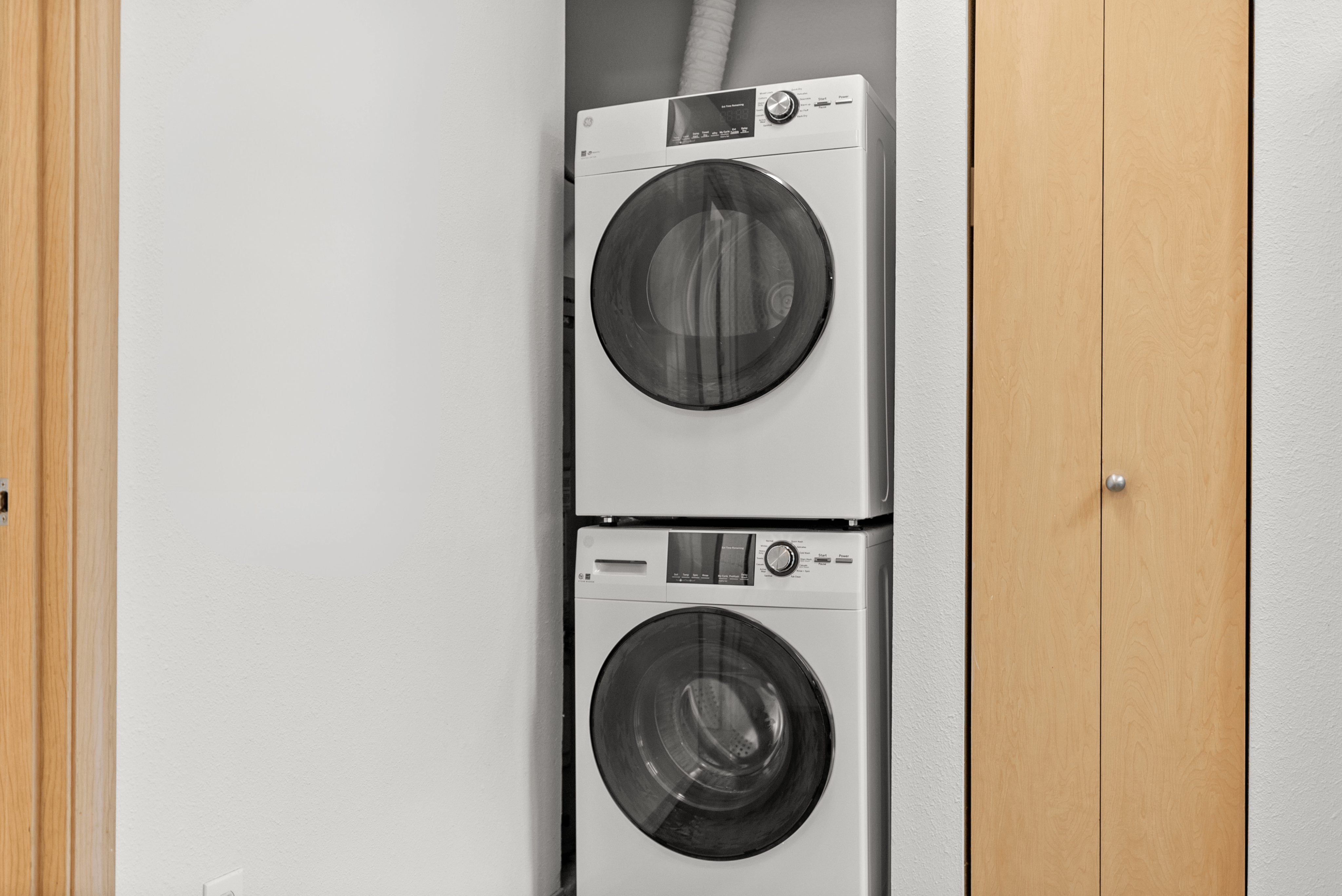 Modern apartment features a convenient in-unit stacked washer and dryer, seamlessly integrated into a sleek closet space.